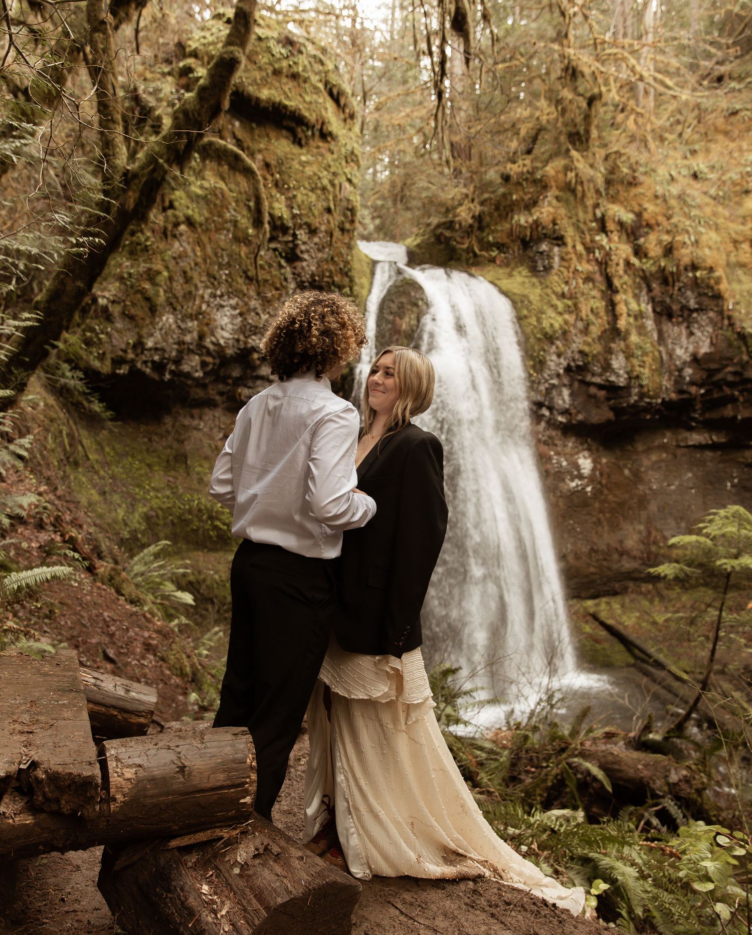 An intimate forest scene with a waterfall creating a natural backdrop for a romantic moment.