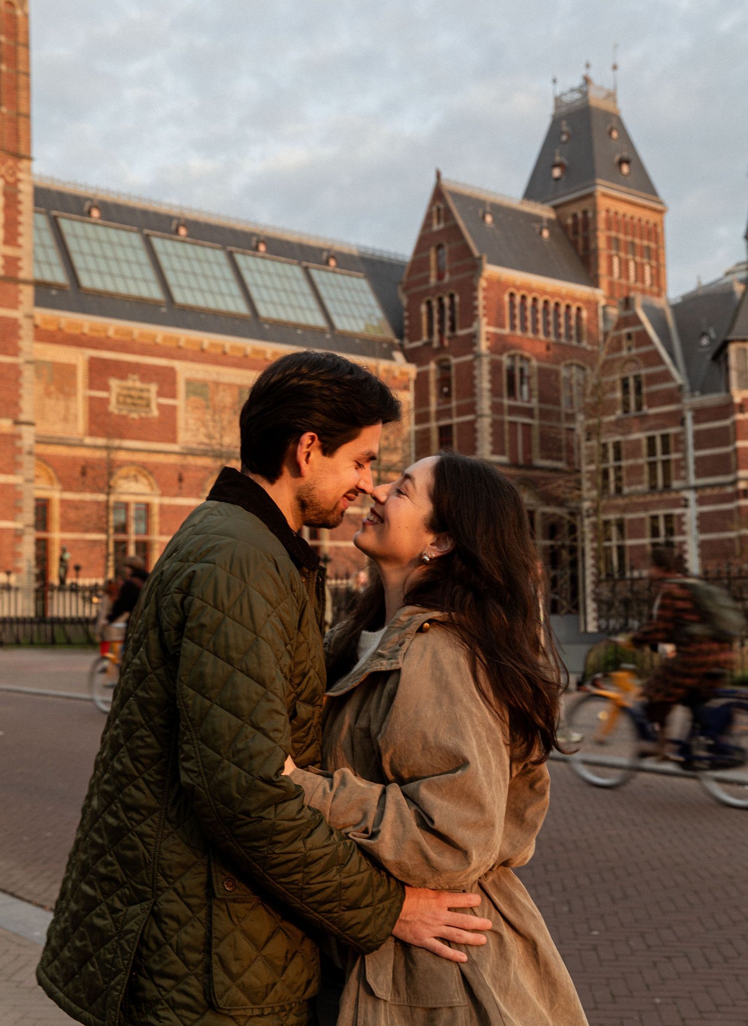 A romantic moment outside the Rijksmuseum in Amsterdam with historic architecture in the background.