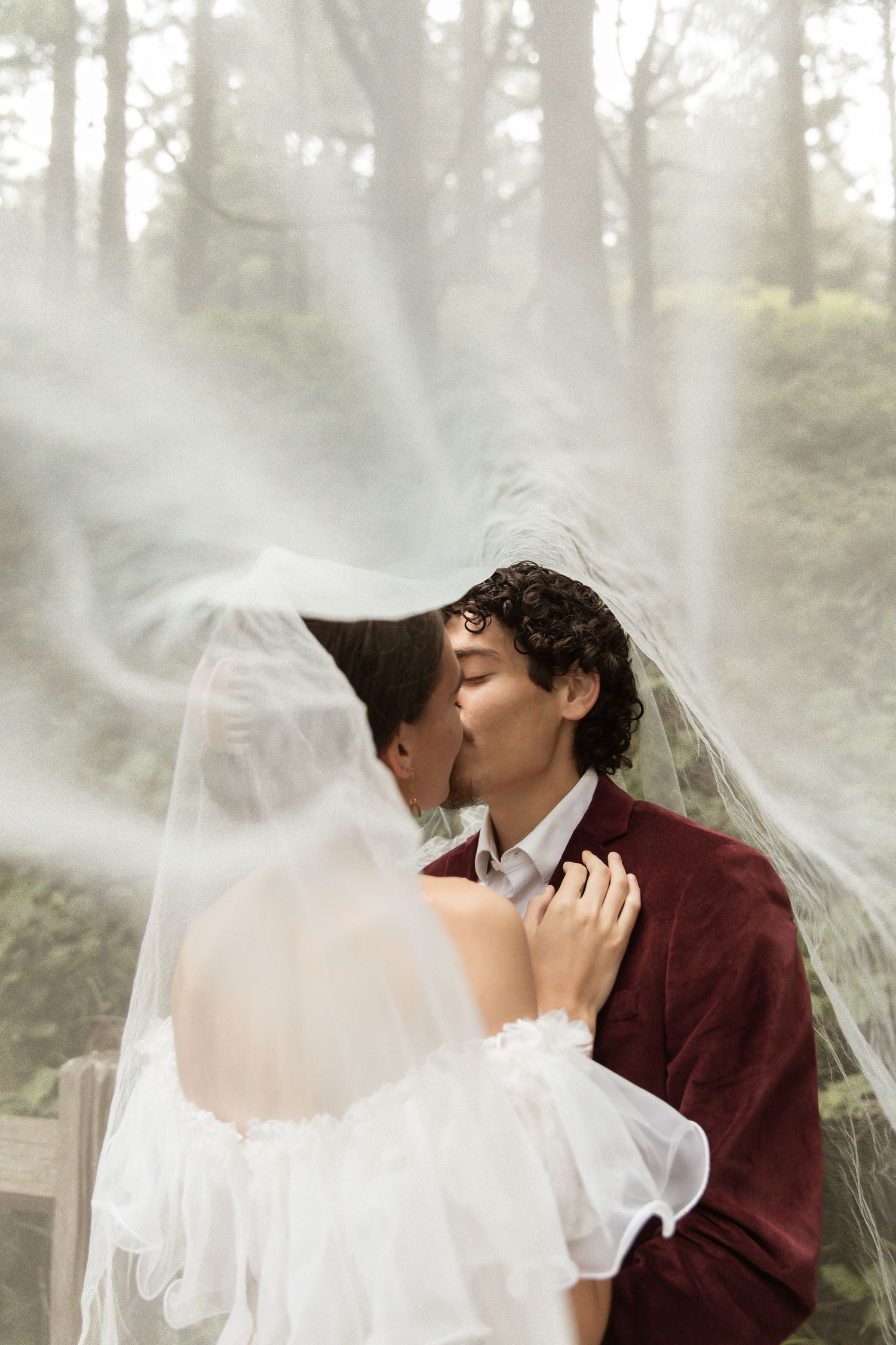 A romantic wedding photo series in a misty forest with ethereal lighting.