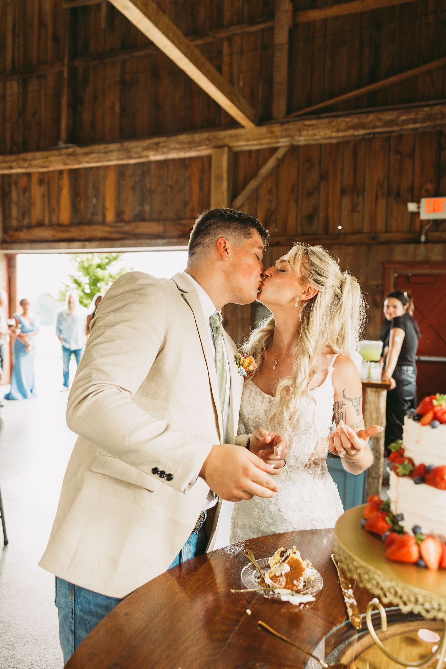 Romantic wedding couple sharing intimate moments in a rustic barn setting with string lights.