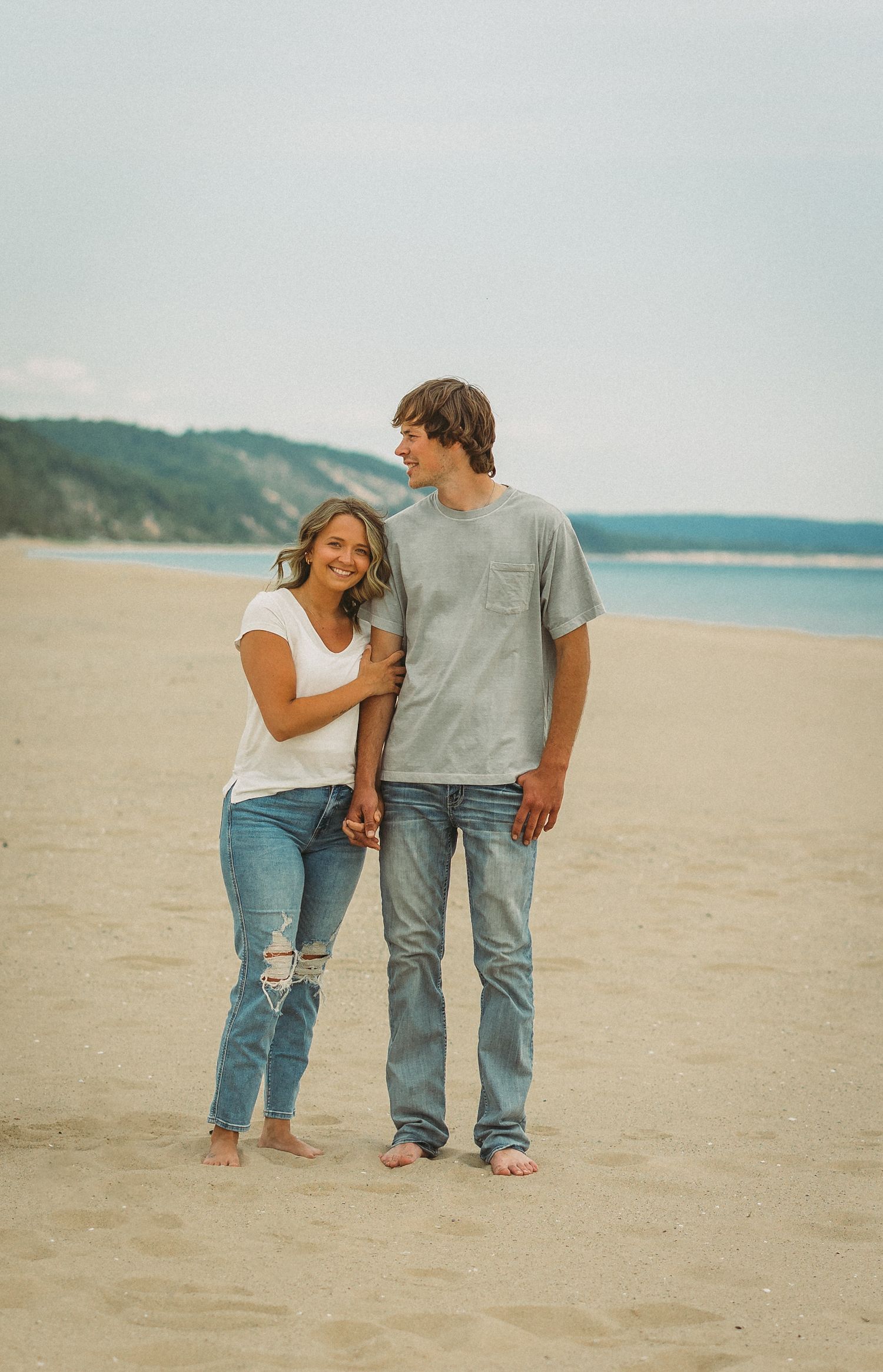 Casual couple photography session on a scenic beach with soft lighting.