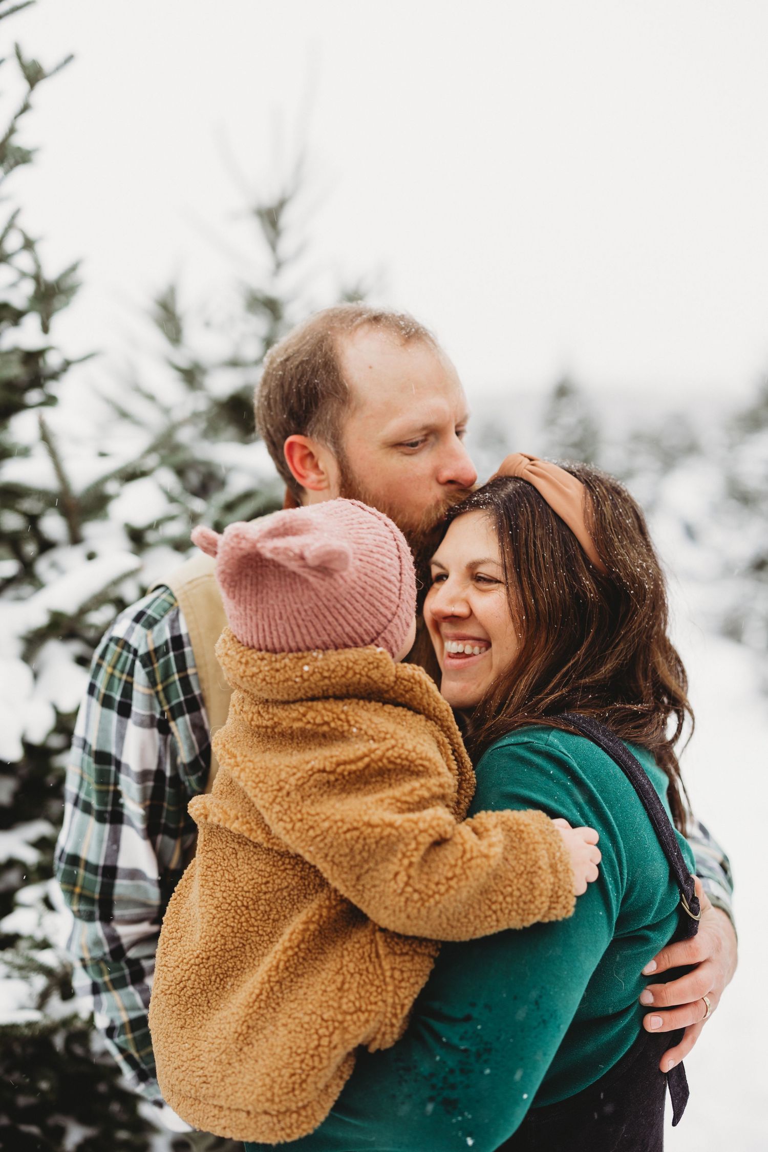 Cozy winter portraits of couple embracing in sherpa jacket and plaid.