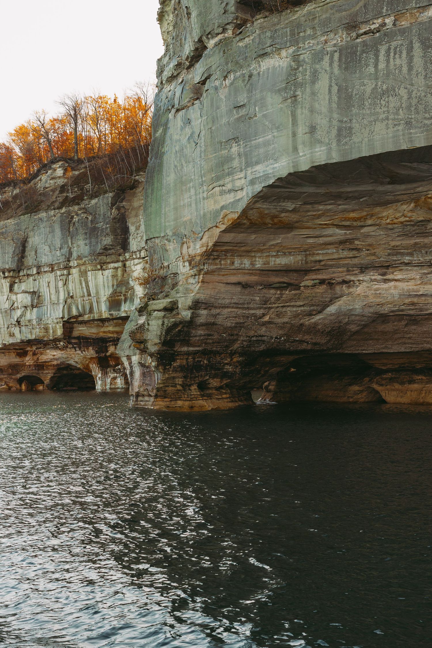 Weathered rock formations along the shoreline with layered sedimentary patterns.