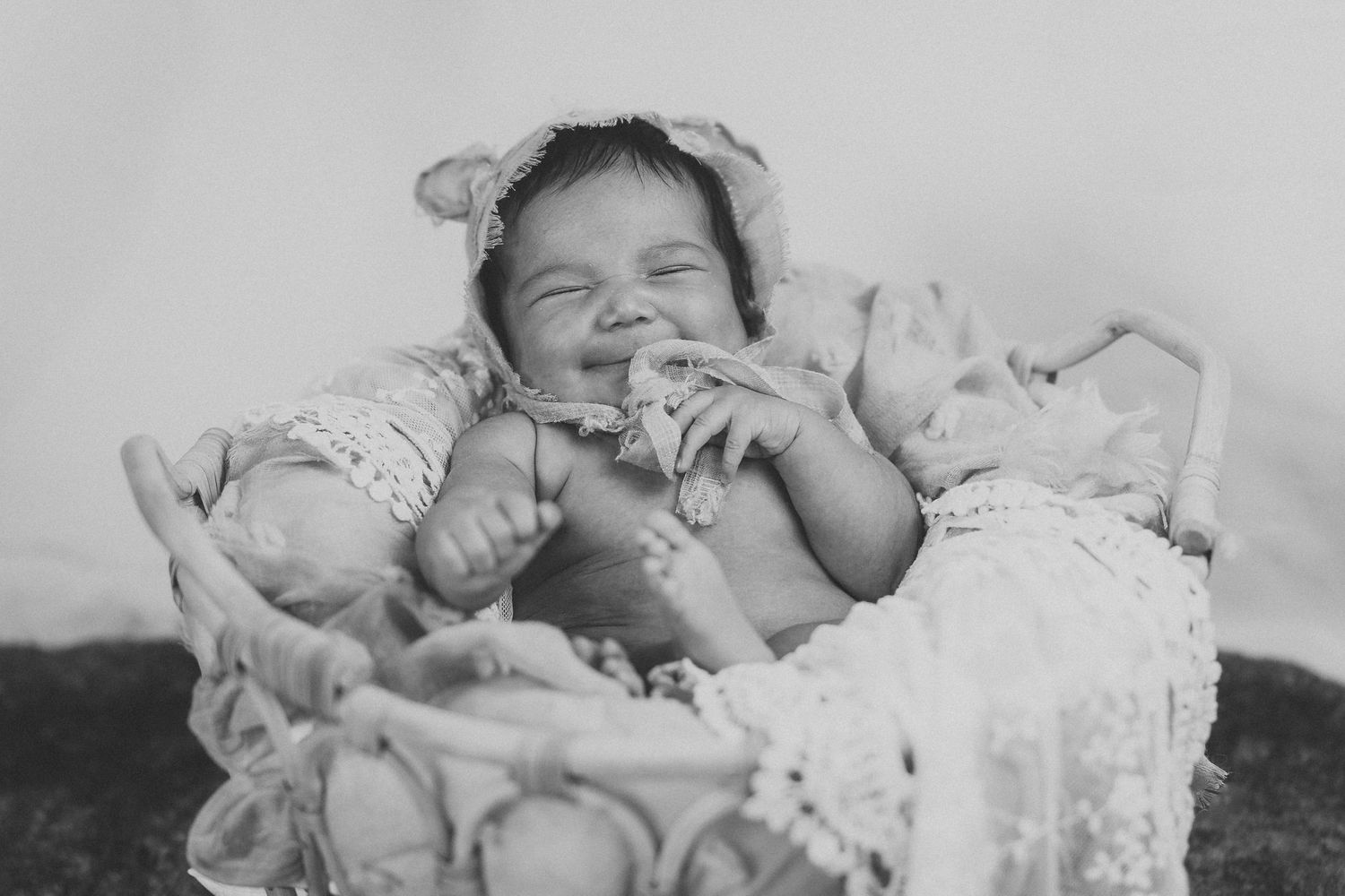 Black and white portrait of sleeping newborn wrapped in delicate lace.