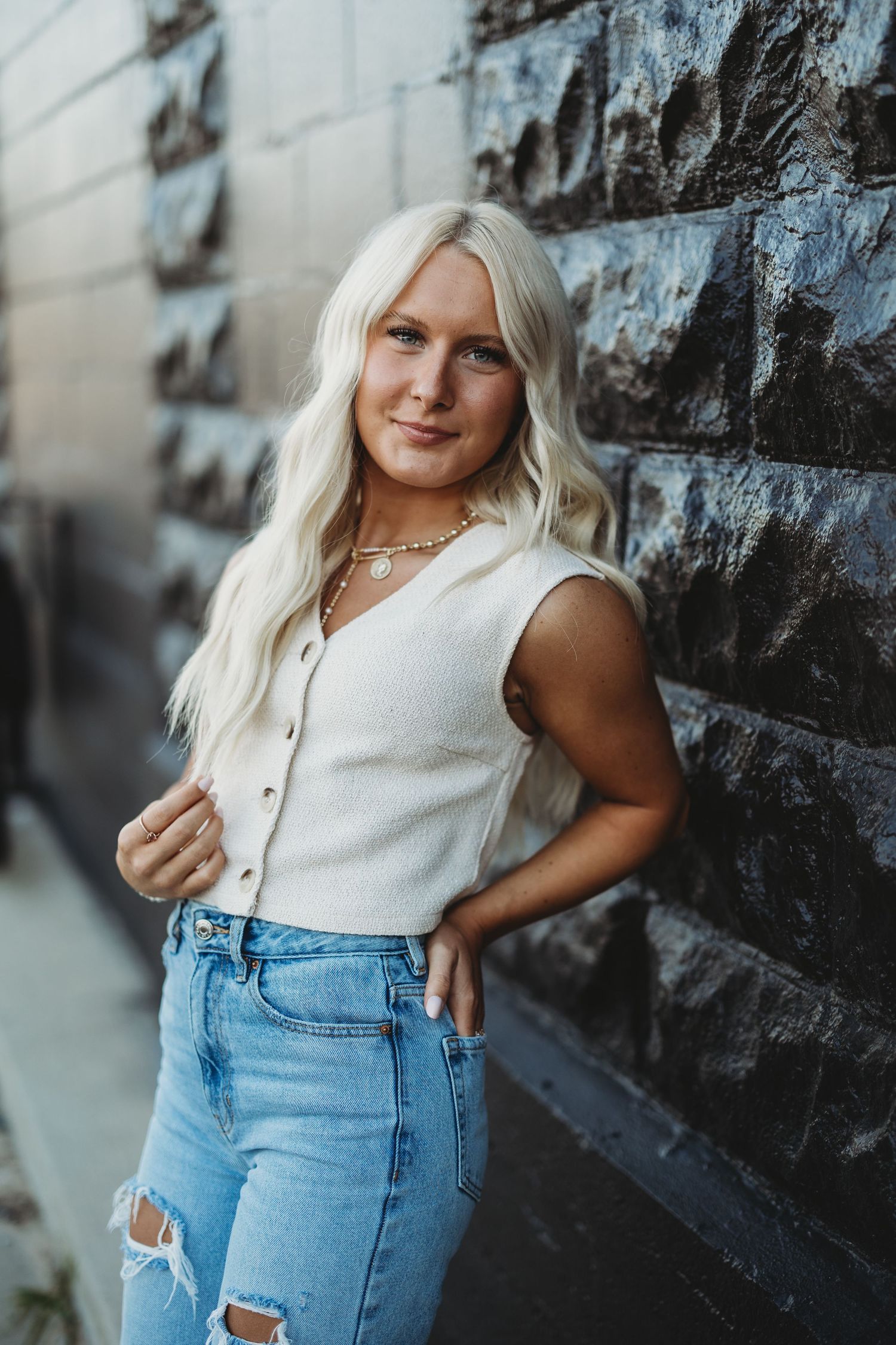 Fashion portrait series against dark wall featuring casual denim and white top outfit.