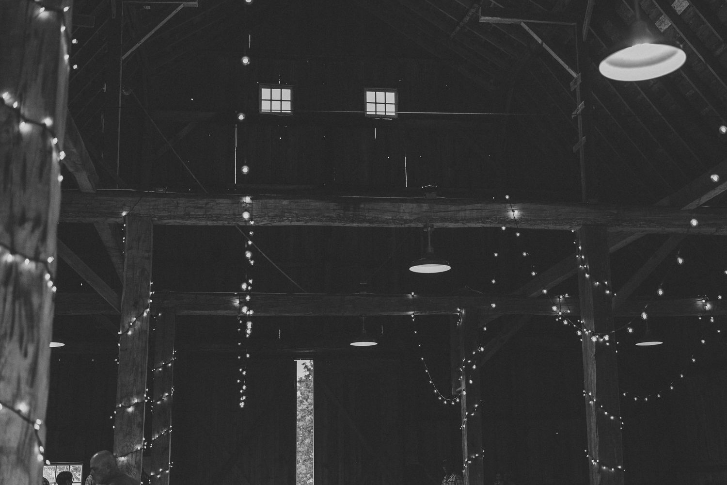 Dark interior venue space illuminated by hanging string lights creating a magical atmosphere.