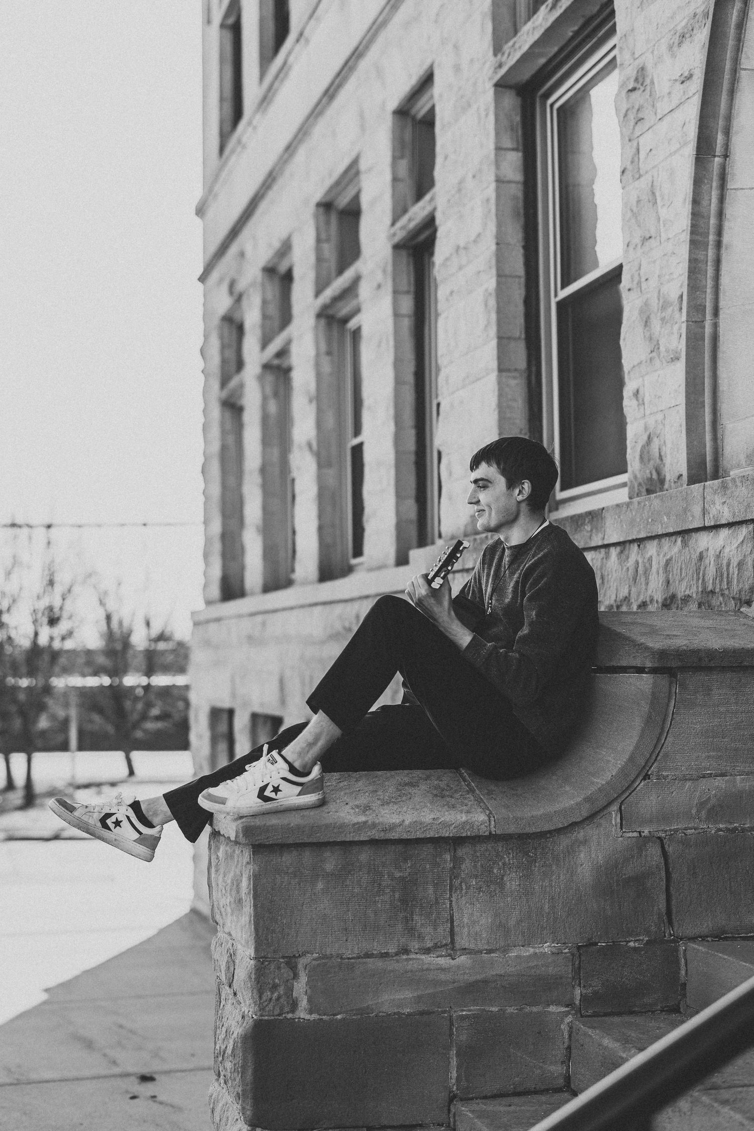 Black and white photo series showing relaxed poses on stone ledge outdoors.