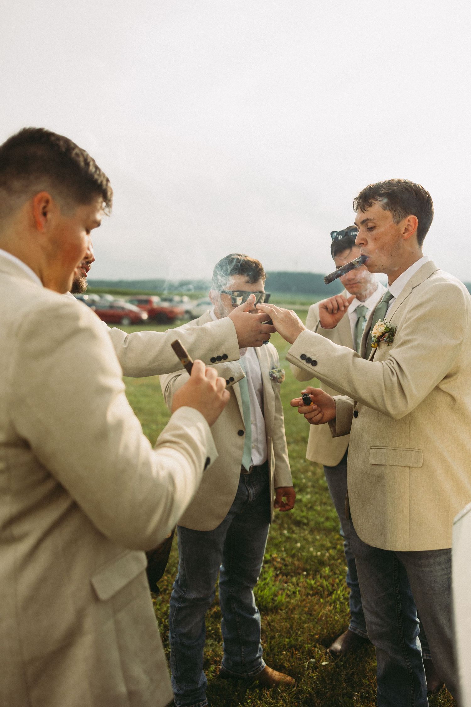 Groomsmen help each other adjust boutonnieres and ties in a series of candid outdoor wedding preparation photos.