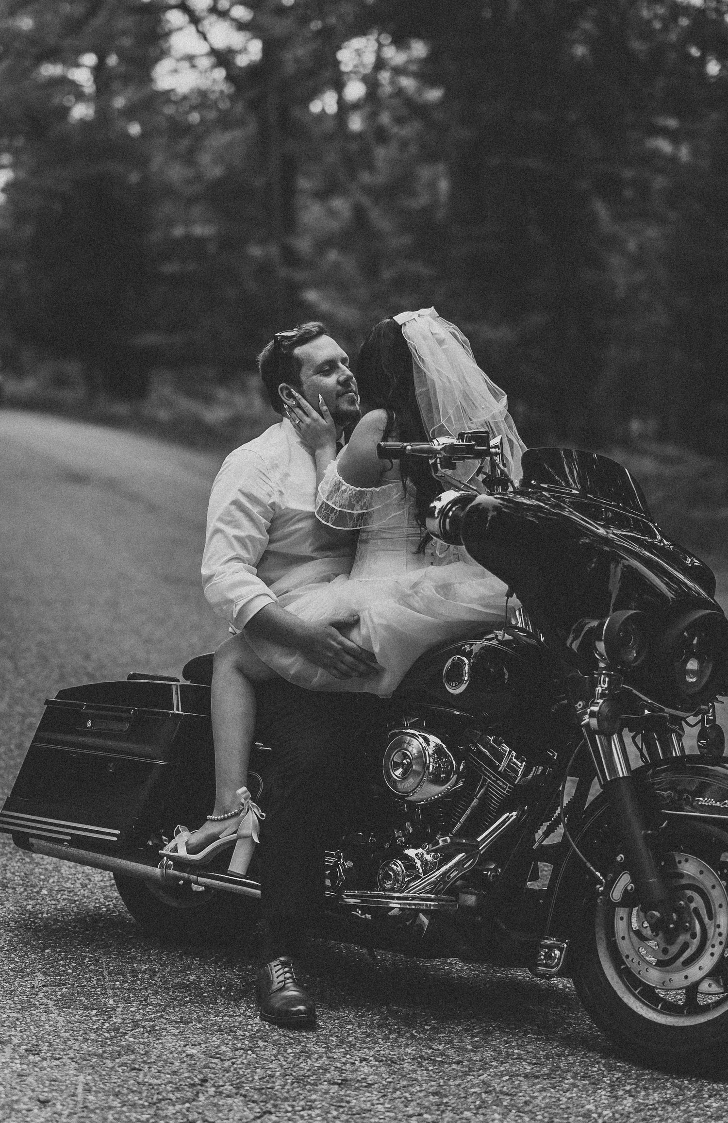 Black and white motorcycle photo series showing romantic poses with a classic cruiser.