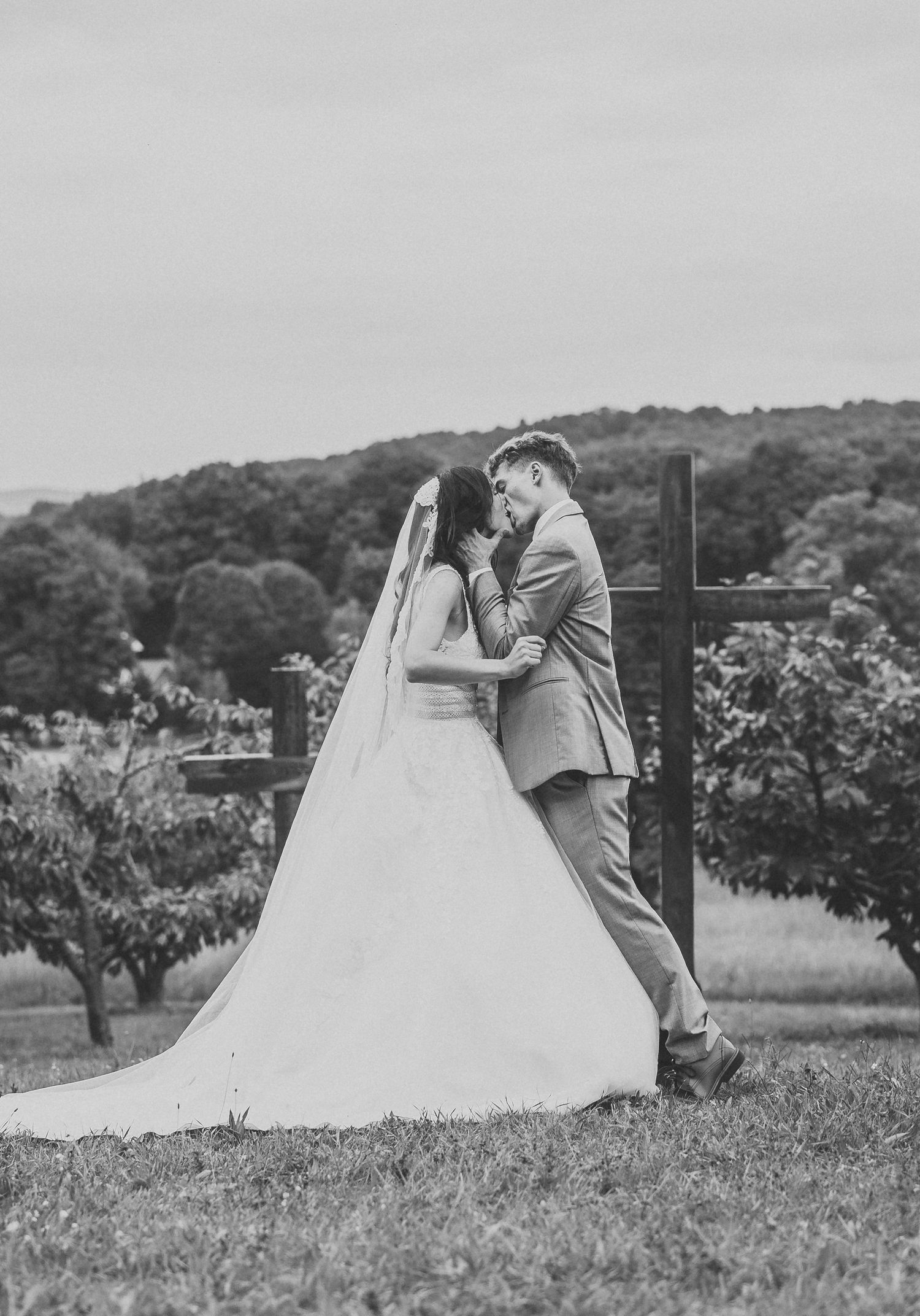 A romantic black and white photo captures a couple's intimate moment during their outdoor wedding.