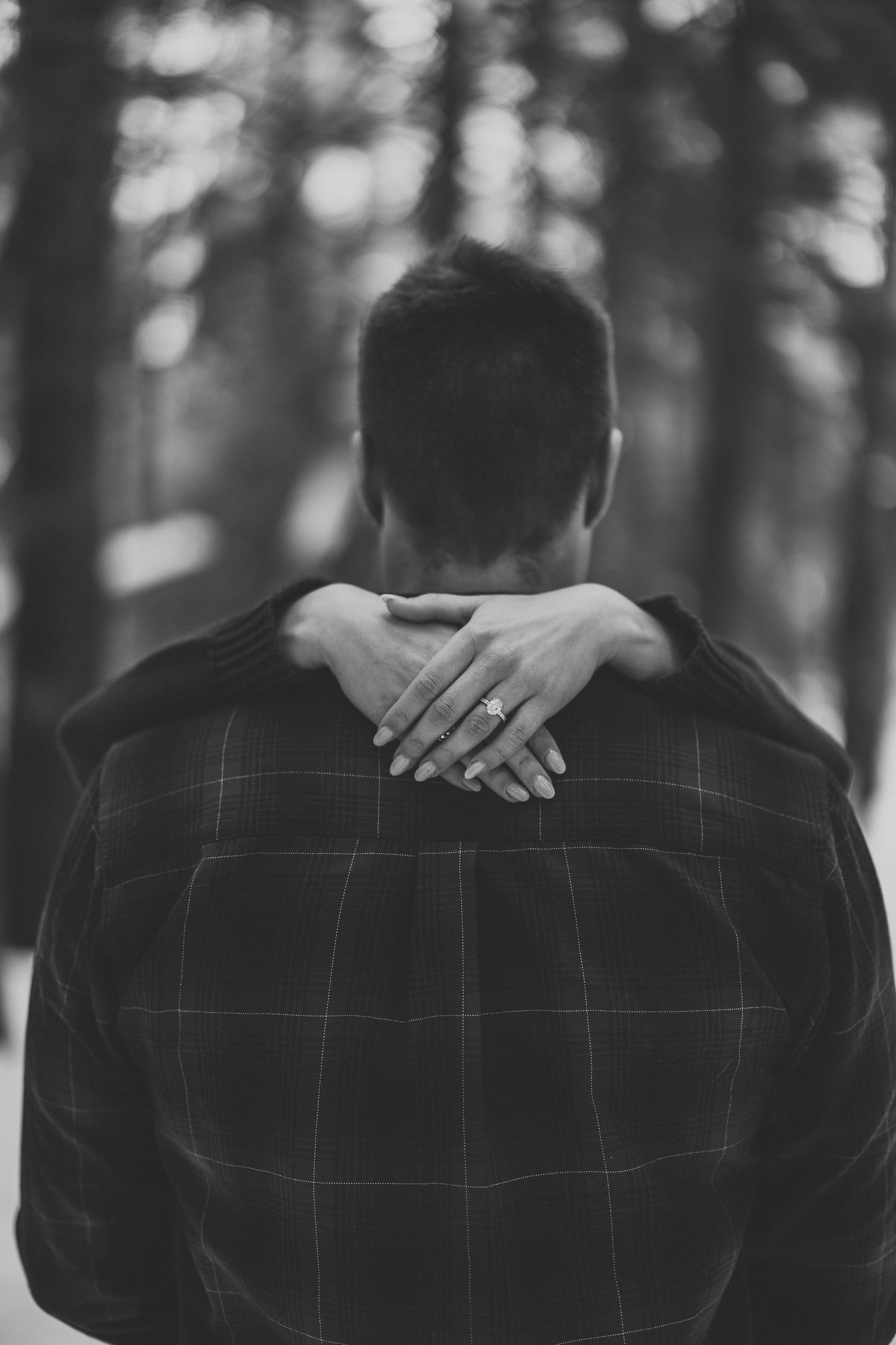 Black and white close-up showing hands placed on a plaid jacket.