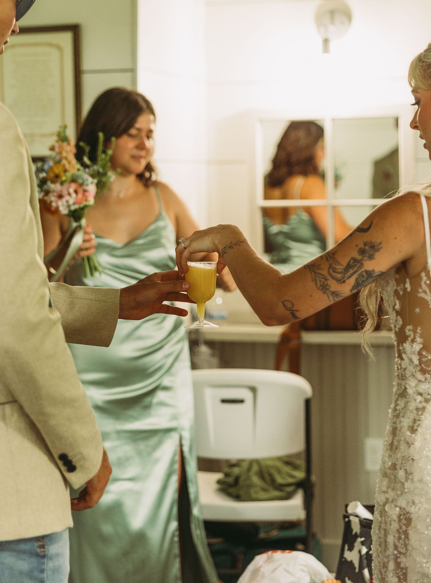 Wedding party members in mint green dresses prepare for celebration indoors.