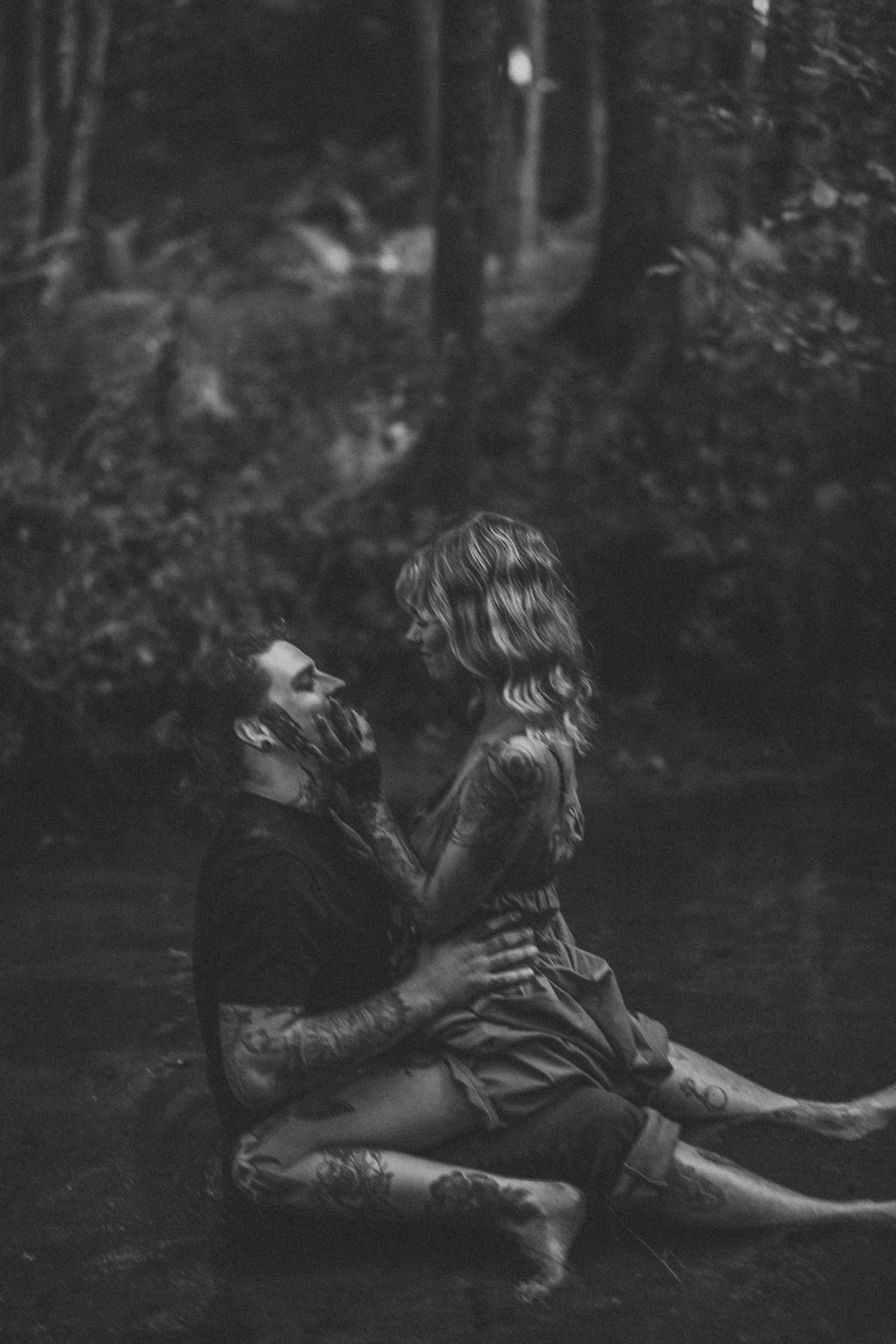 A romantic black and white photo of a couple lying in nature.