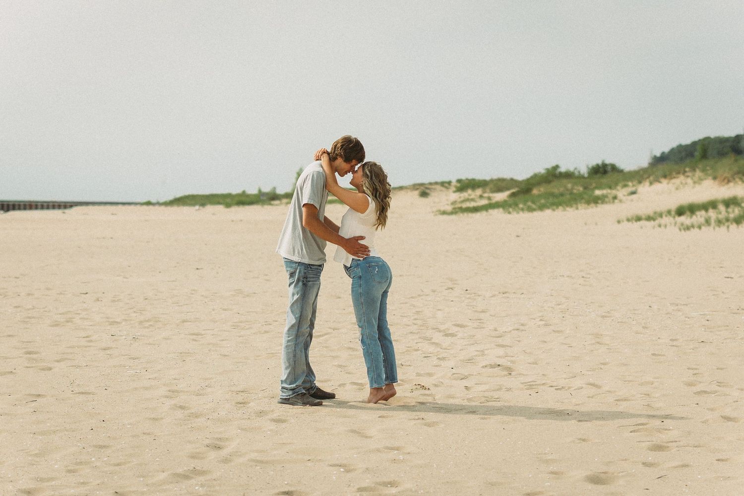 A series of romantic beach photos showing tender moments against a coastal backdrop.