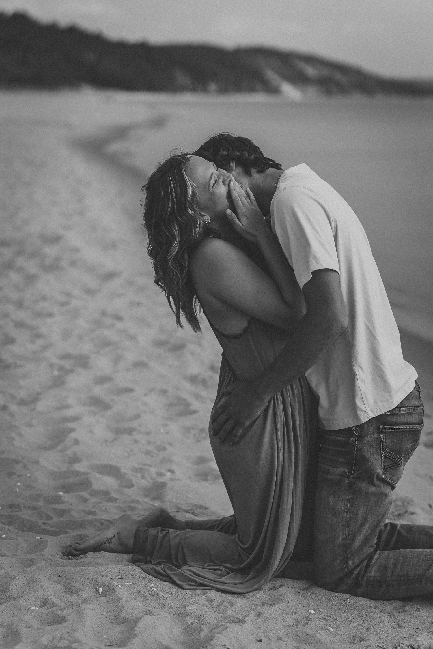 A romantic black and white photo sequence shows a couple sharing an intimate moment on a sandy beach.