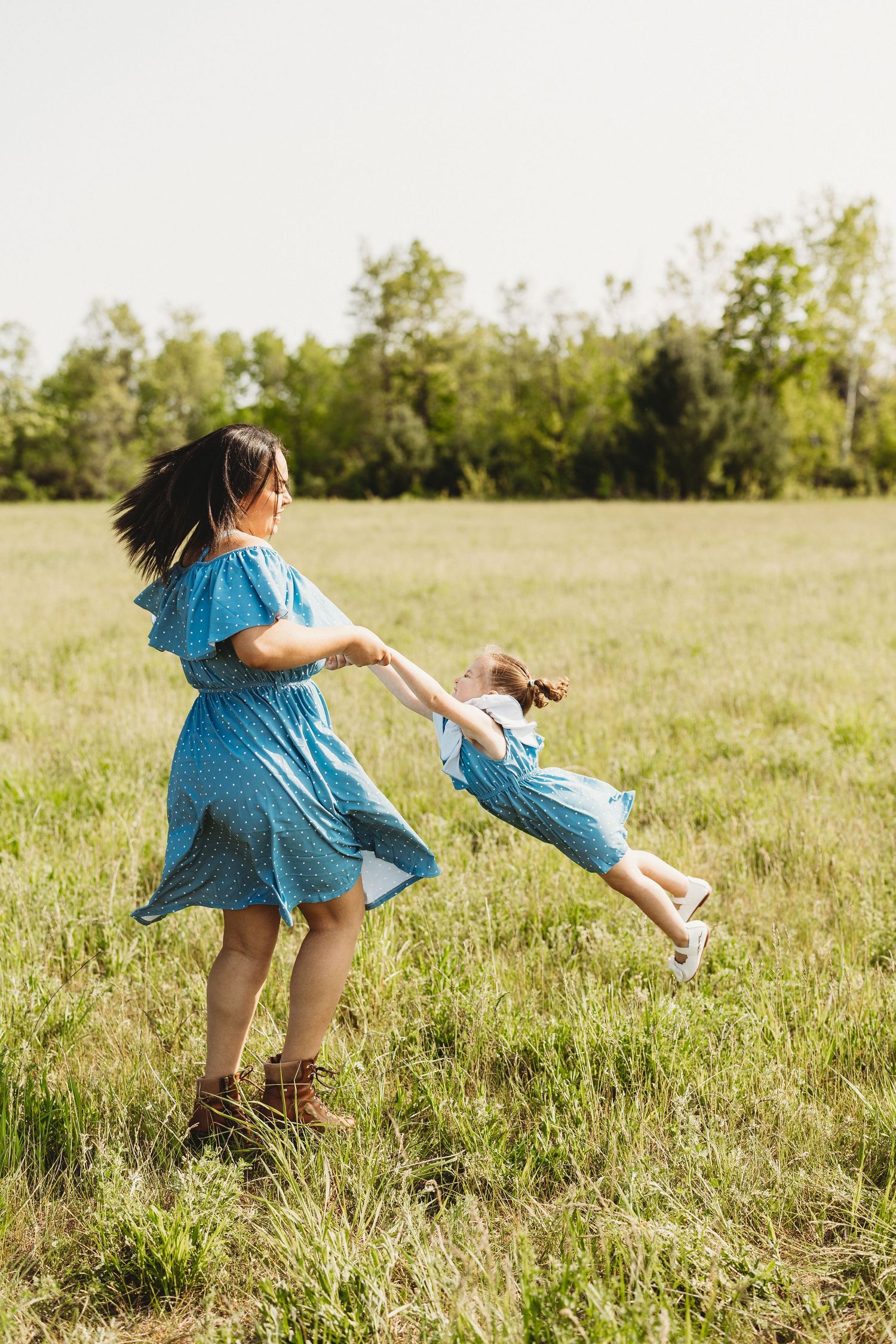 A playful sequence shows someone spinning and twirling with joy in a grassy summer field.