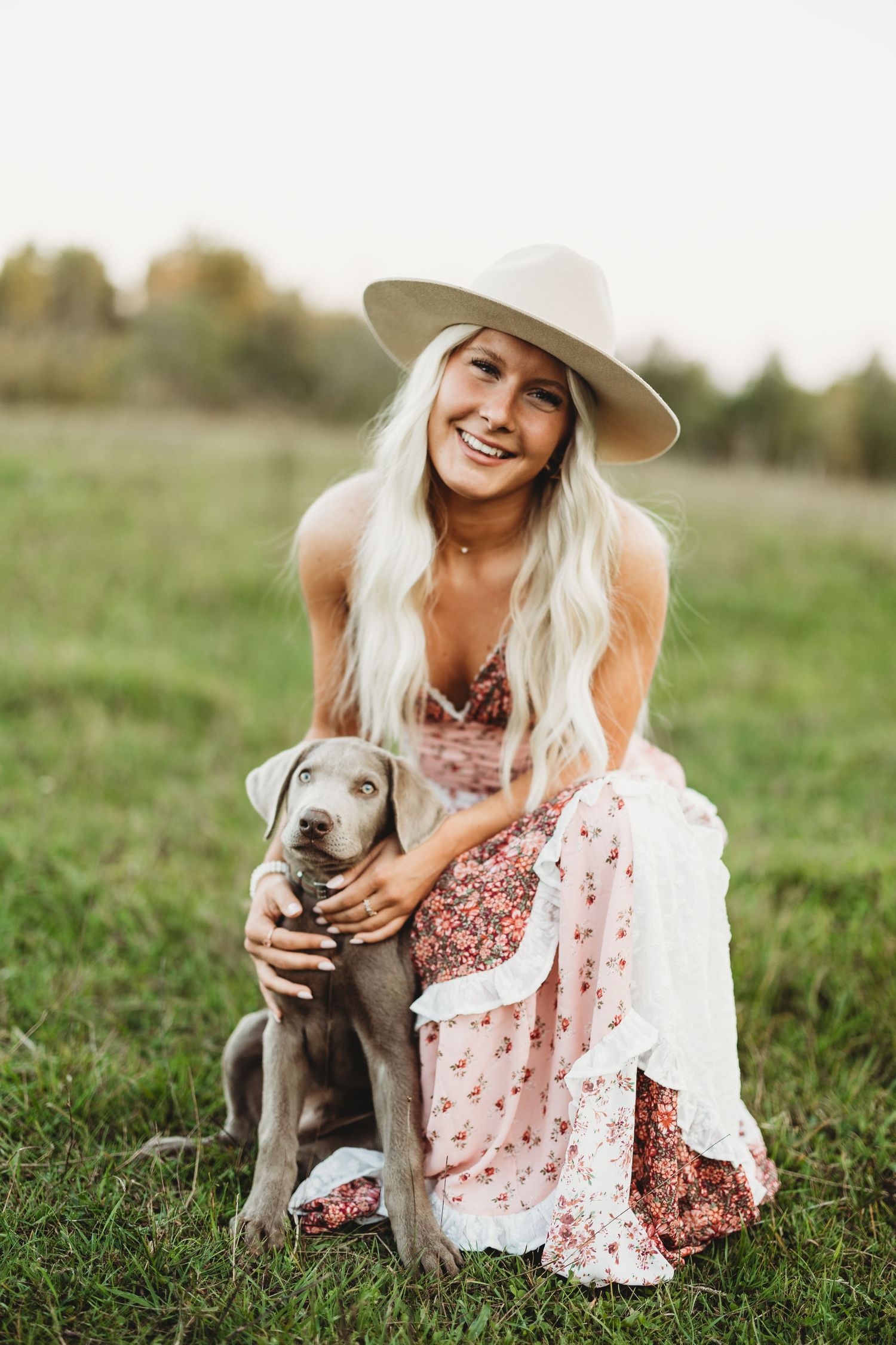 Sweet moment with a small grey puppy in a floral dress outdoors.