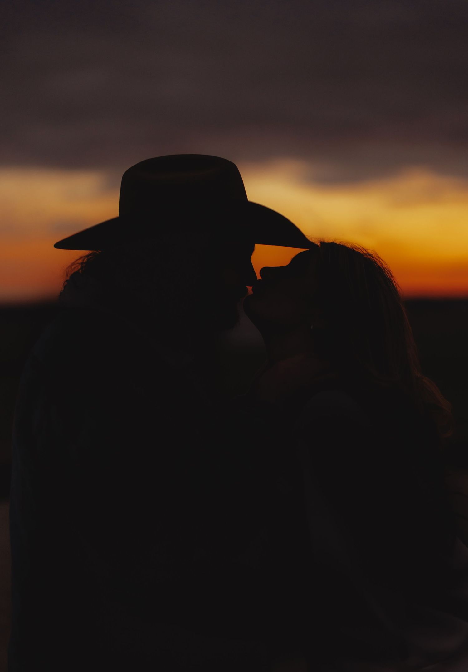 Silhouettes against a dramatic sunset sky creating a romantic atmosphere.