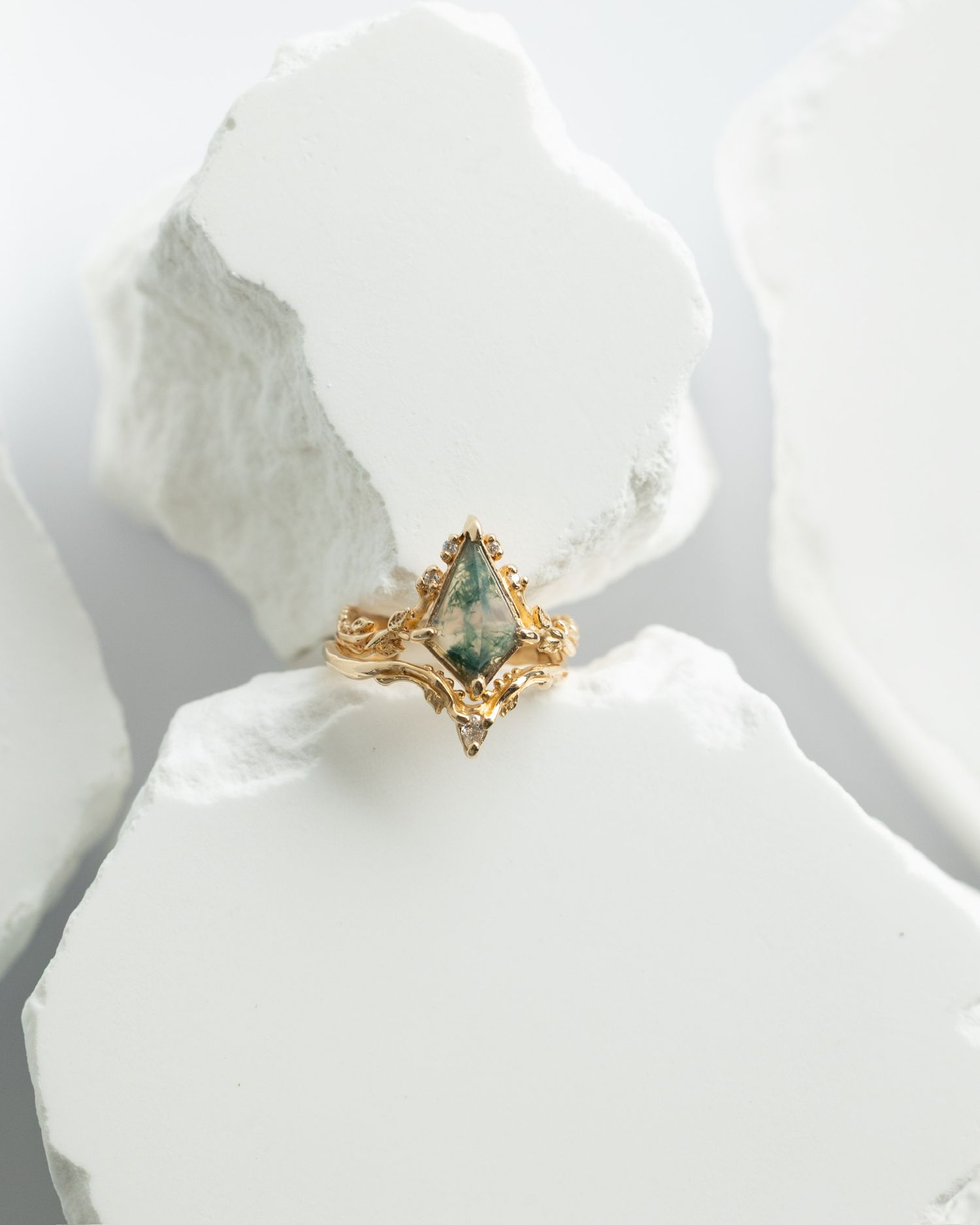 Dainty gold ring with turquoise stone and diamond accents on white surface.