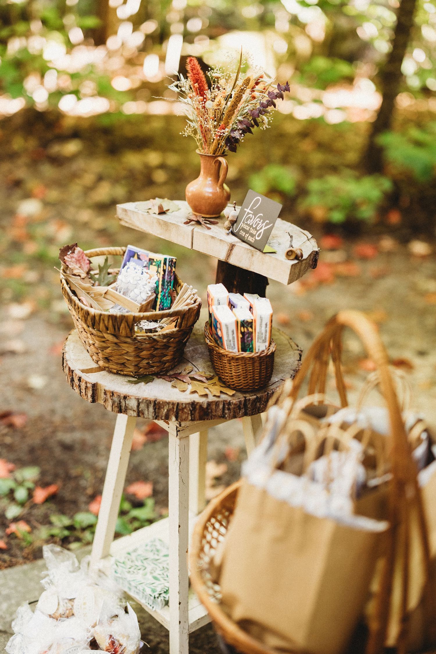 Rustic wooden tiered display stands with vintage decor and baskets arranged for a woodland-themed event setup.