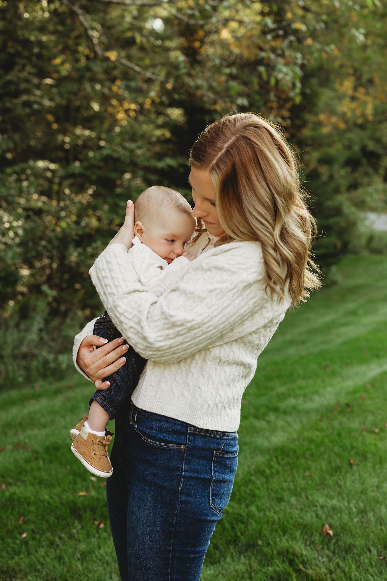 A tender moment captured in a series of photos showing affectionate embraces on a grassy lawn in autumn.