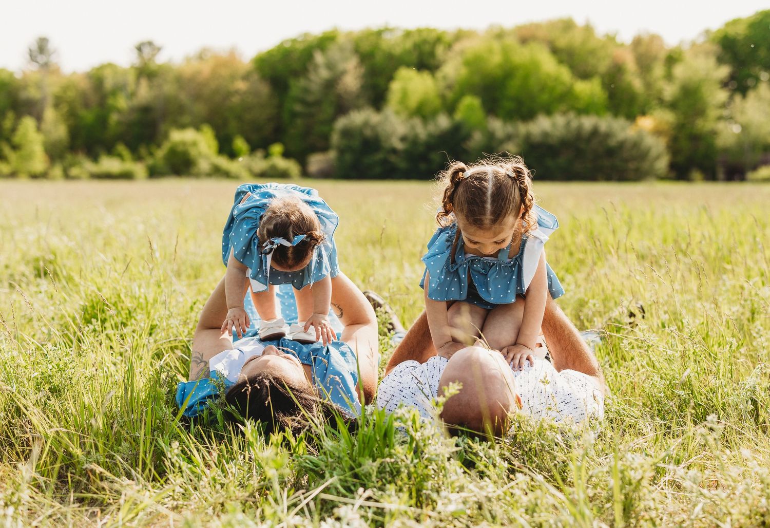 People lying in a row on grass reading books together in a sunny meadow on a summer day.
