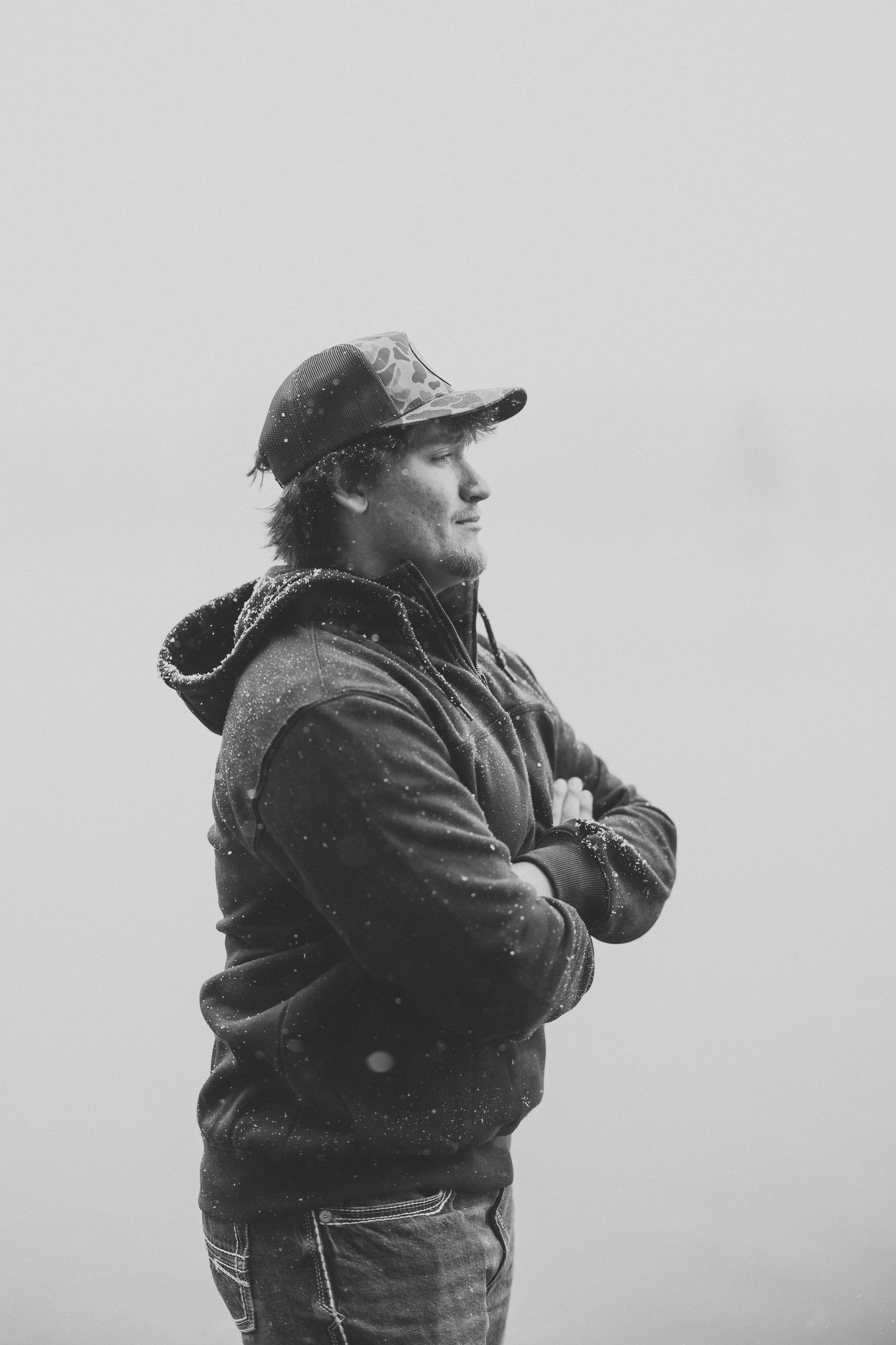 Black and white portrait of person in baseball cap and jacket.