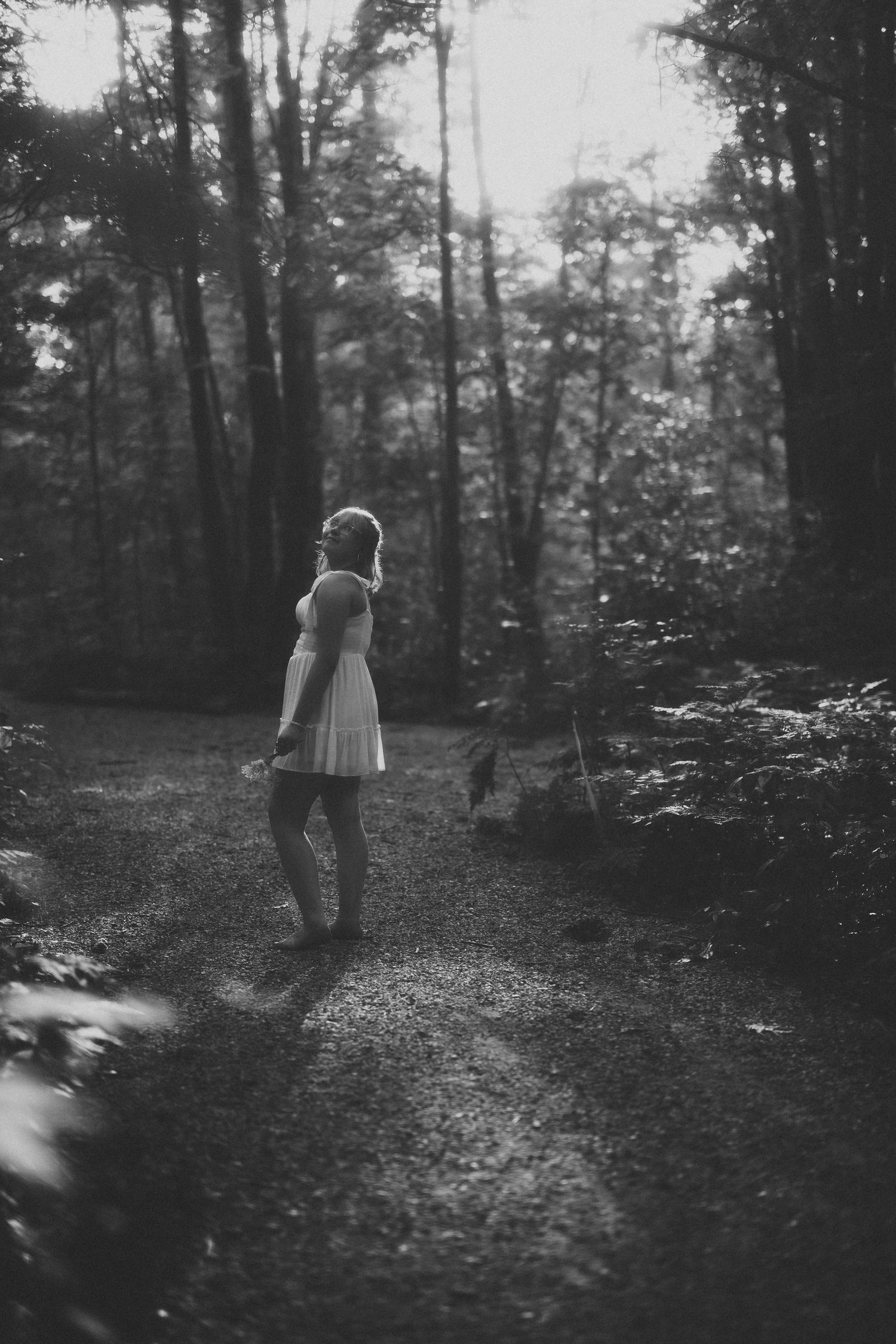 Ethereal black and white image of person walking through misty forest path.