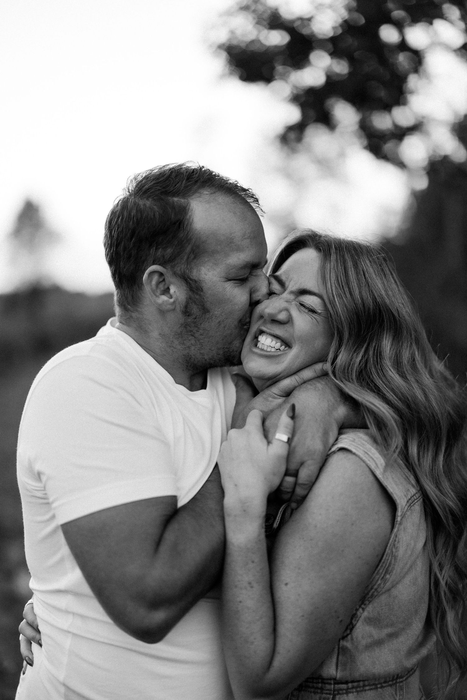 A romantic black and white photo sequence shows a couple sharing intimate moments and laughter together outdoors.