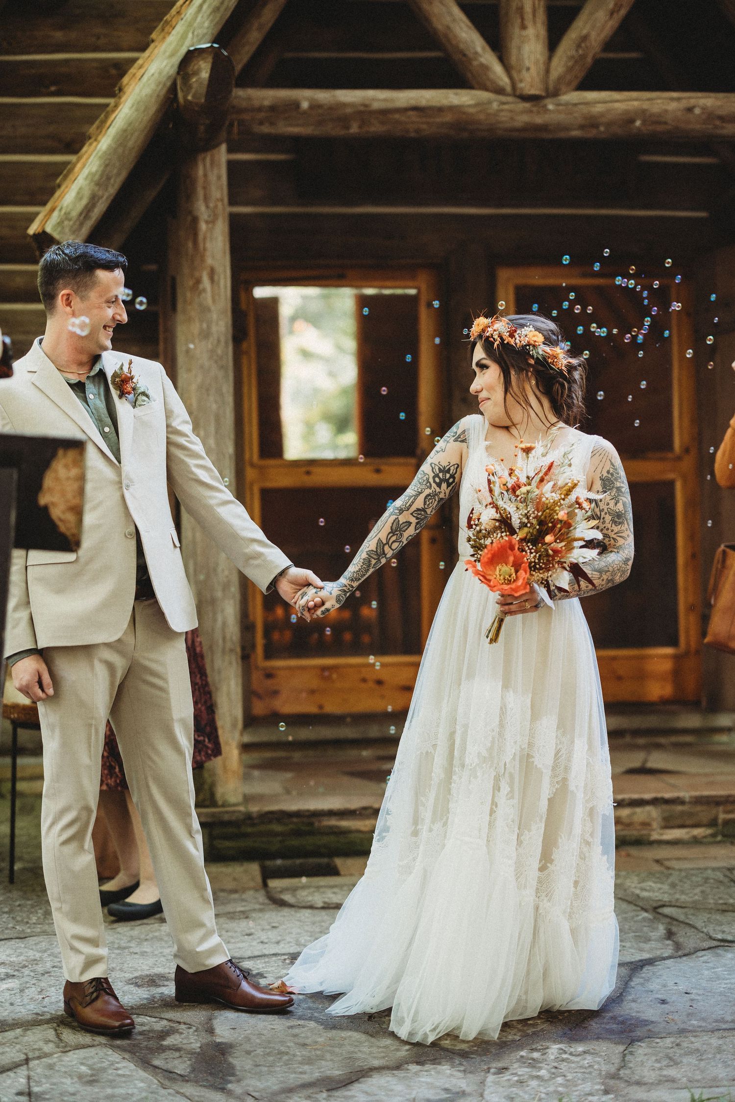 Romantic wedding couple shares intimate dance moments on rustic stone patio with wooden beams overhead.