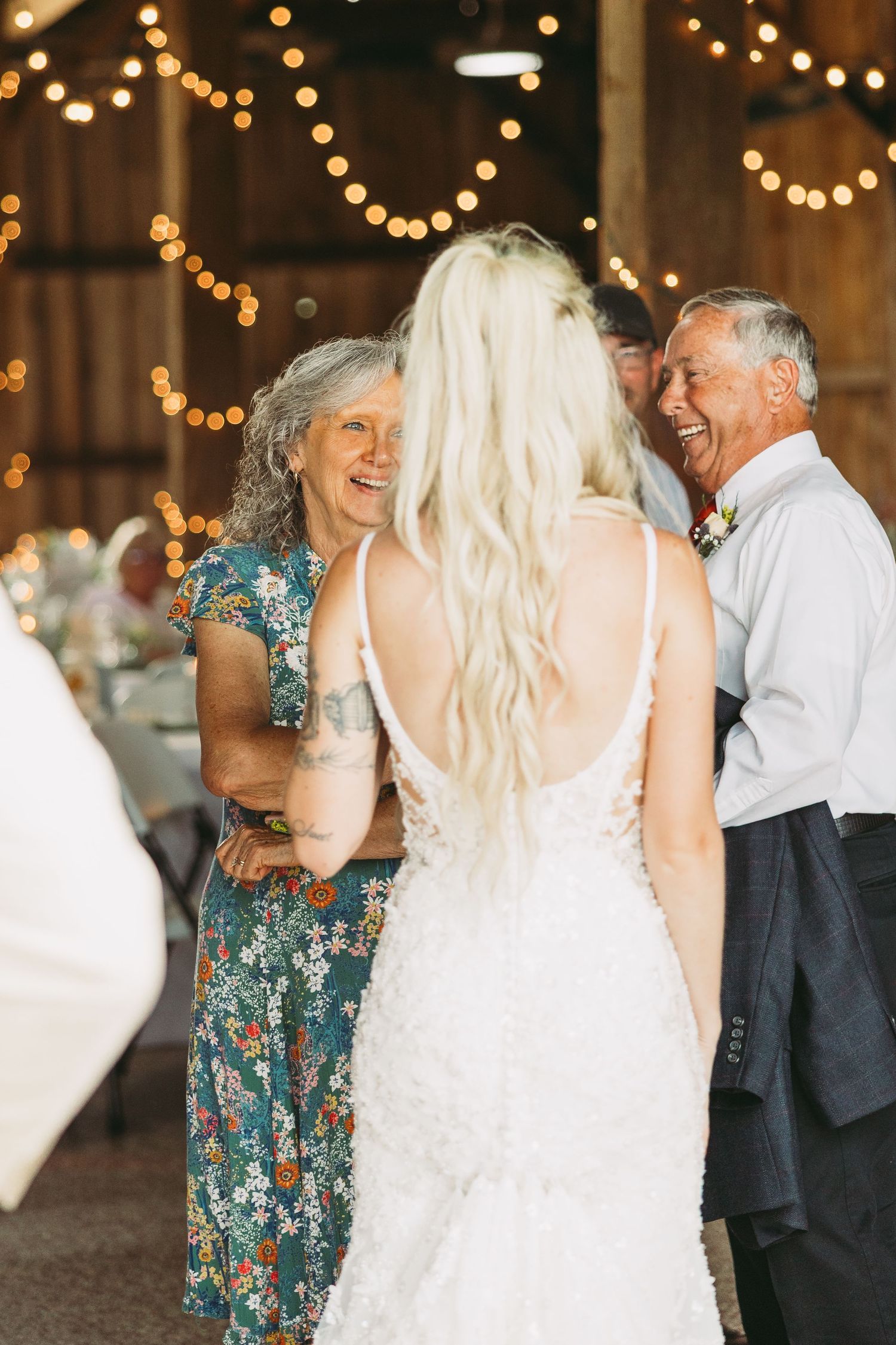 Wedding reception dance scene with string lights and guests celebrating in a rustic venue.
