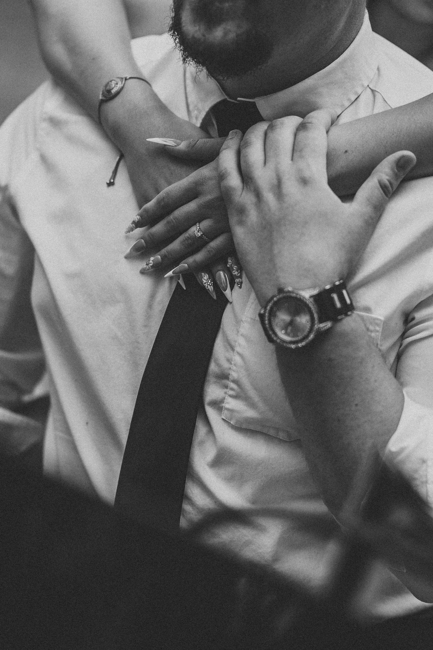 Intimate black and white close-up detail shots showing hands and formal attire.