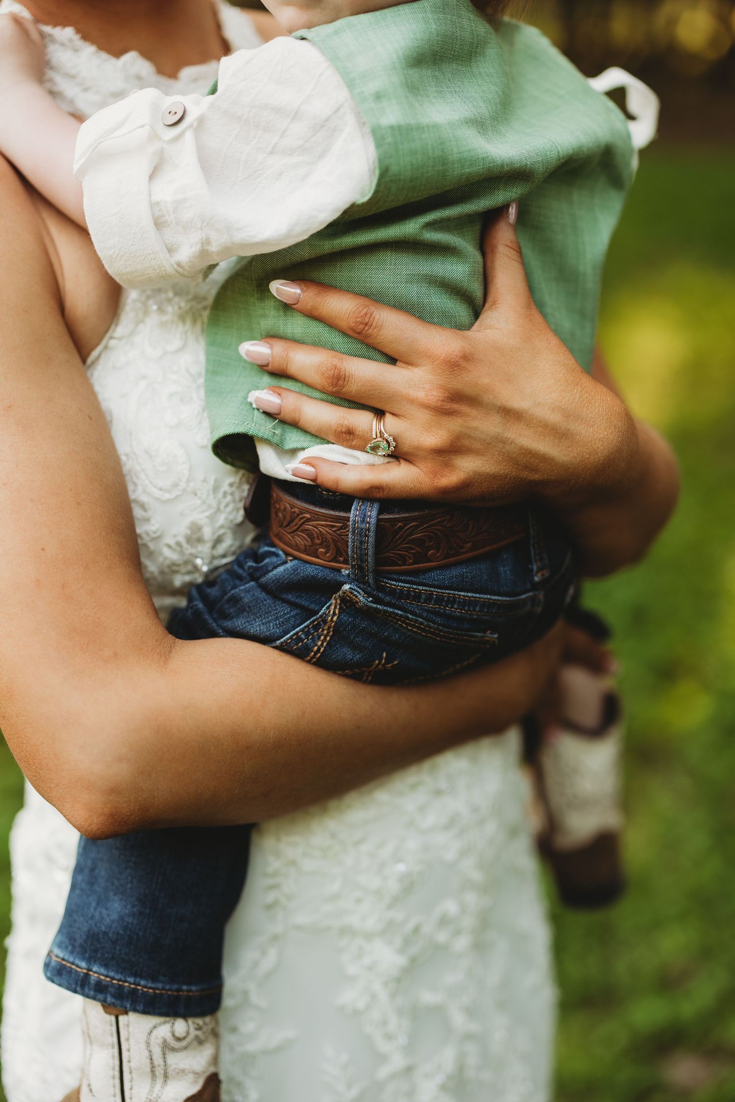 Close-up shot showing hands holding a white dress against blue denim in an outdoor setting.