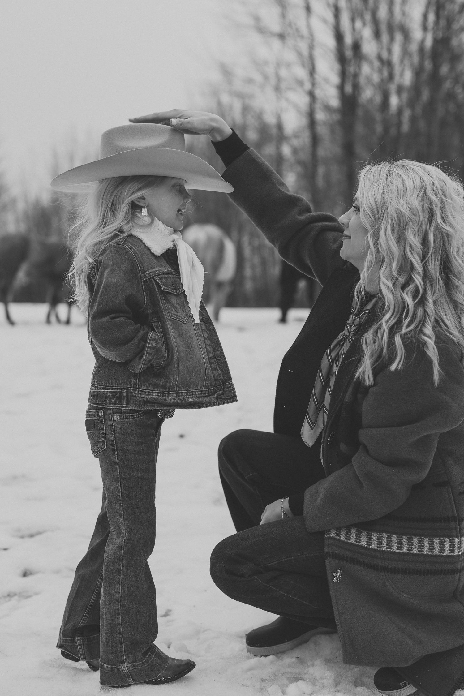 A series of photos showing a small child playing in the snow while wearing winter boots and denim.