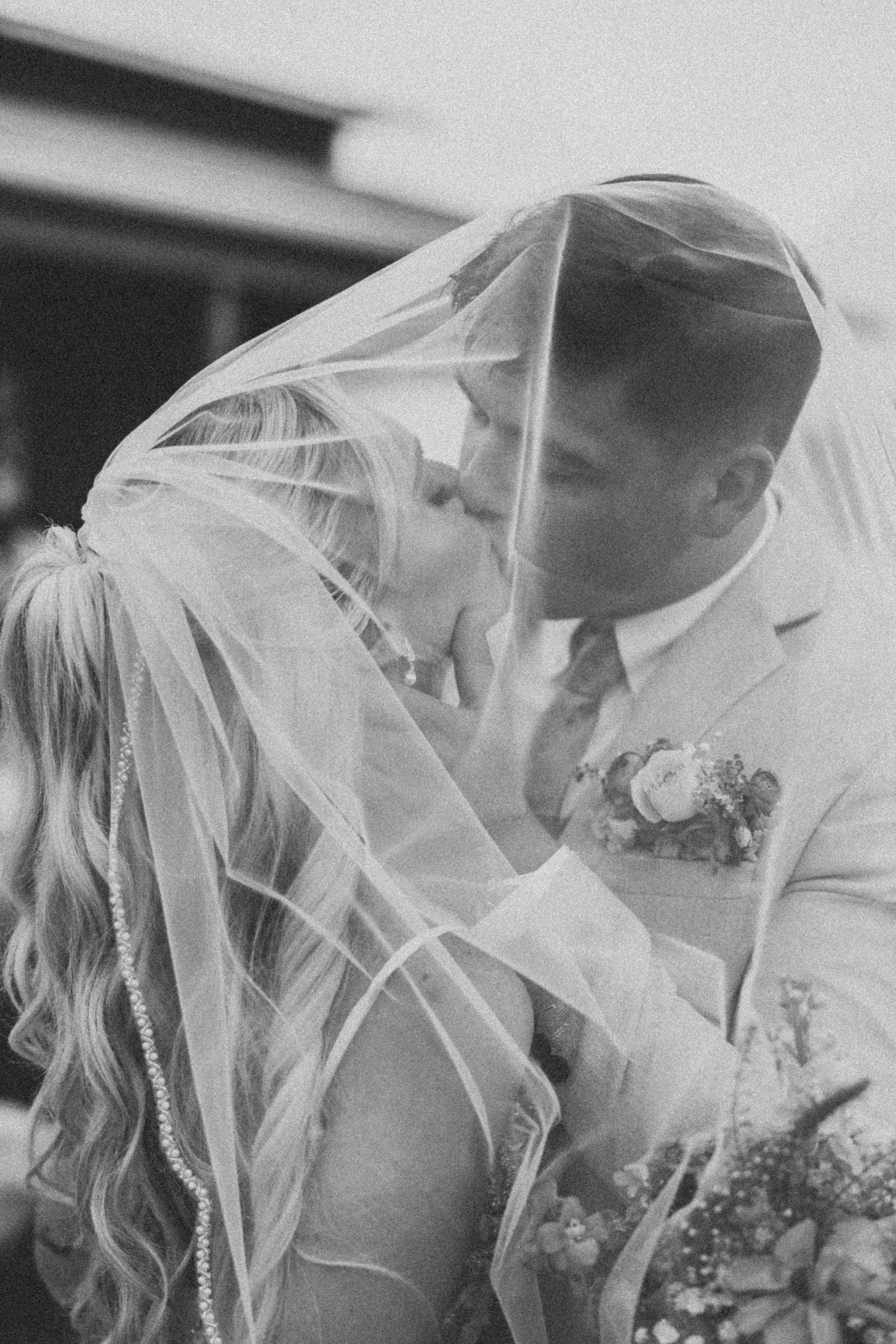 A romantic black and white photo sequence showing a couple sharing an intimate moment under a wedding veil.