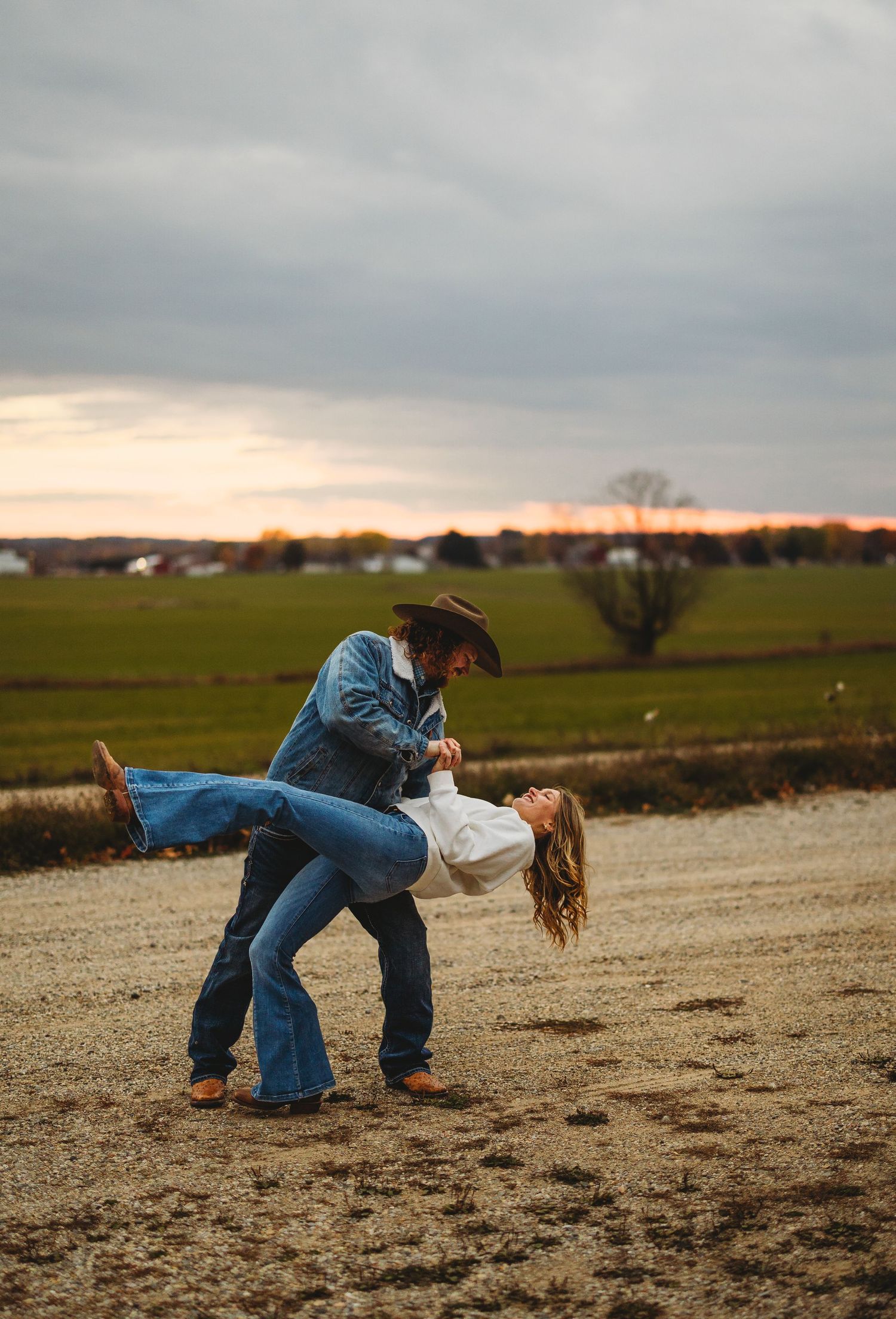 Playful dance moves captured in a field at sunset.