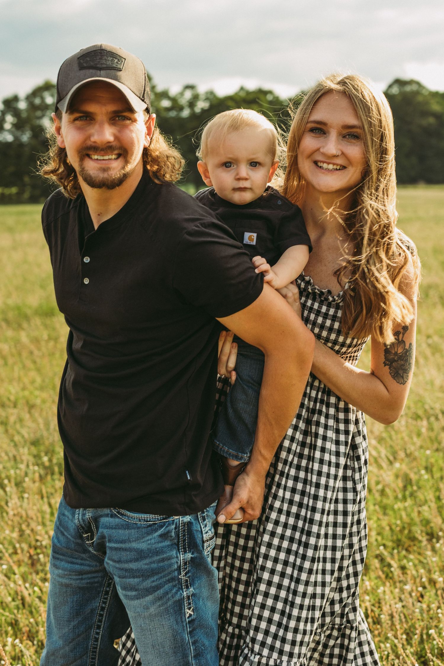 Family enjoying a warm summer evening together in a wildflower meadow.