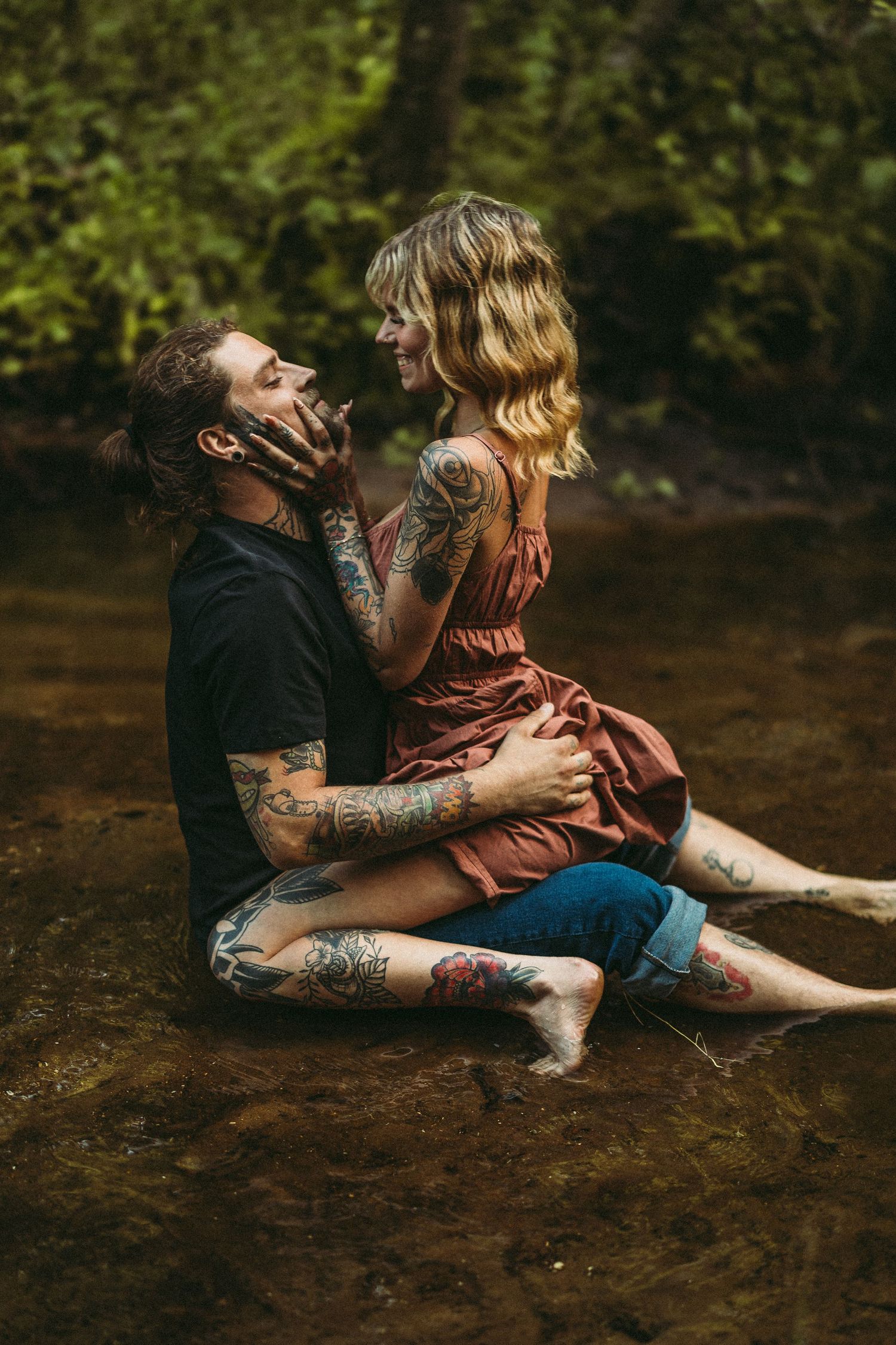 A couple sitting by the water's edge sharing an intimate moment.