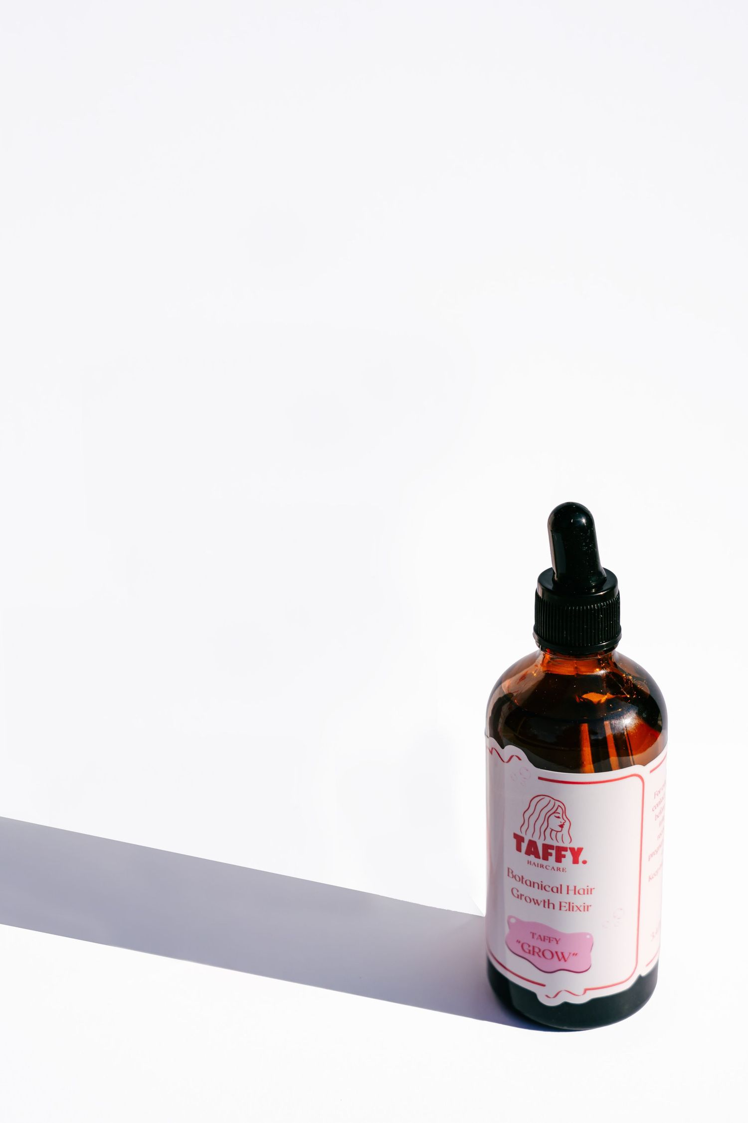 Yaffy amber glass dropper bottle of Inspired Hair Growth Elixir on white background with soft shadow.