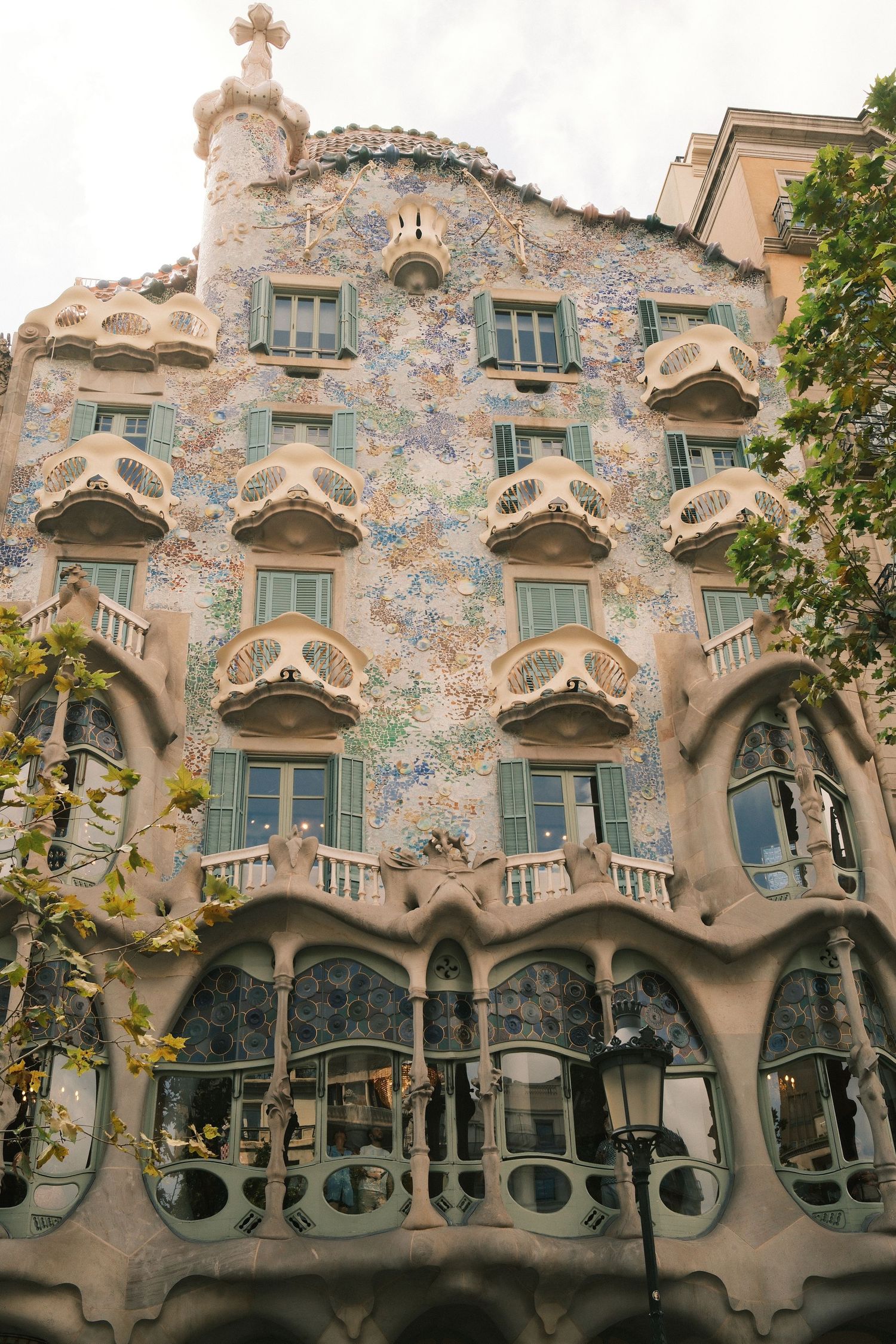 Casa Batllo facade in Barcelona featuring Gaudi's mosaic tilework, bone-like columns, and organic balconies.