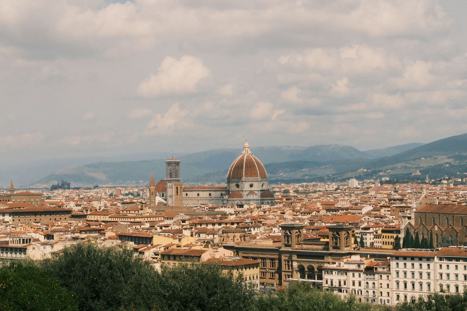 Panoramic view of Florence skyline with the iconic Duomo cathedral dome rising above terracotta rooftops, Italy.