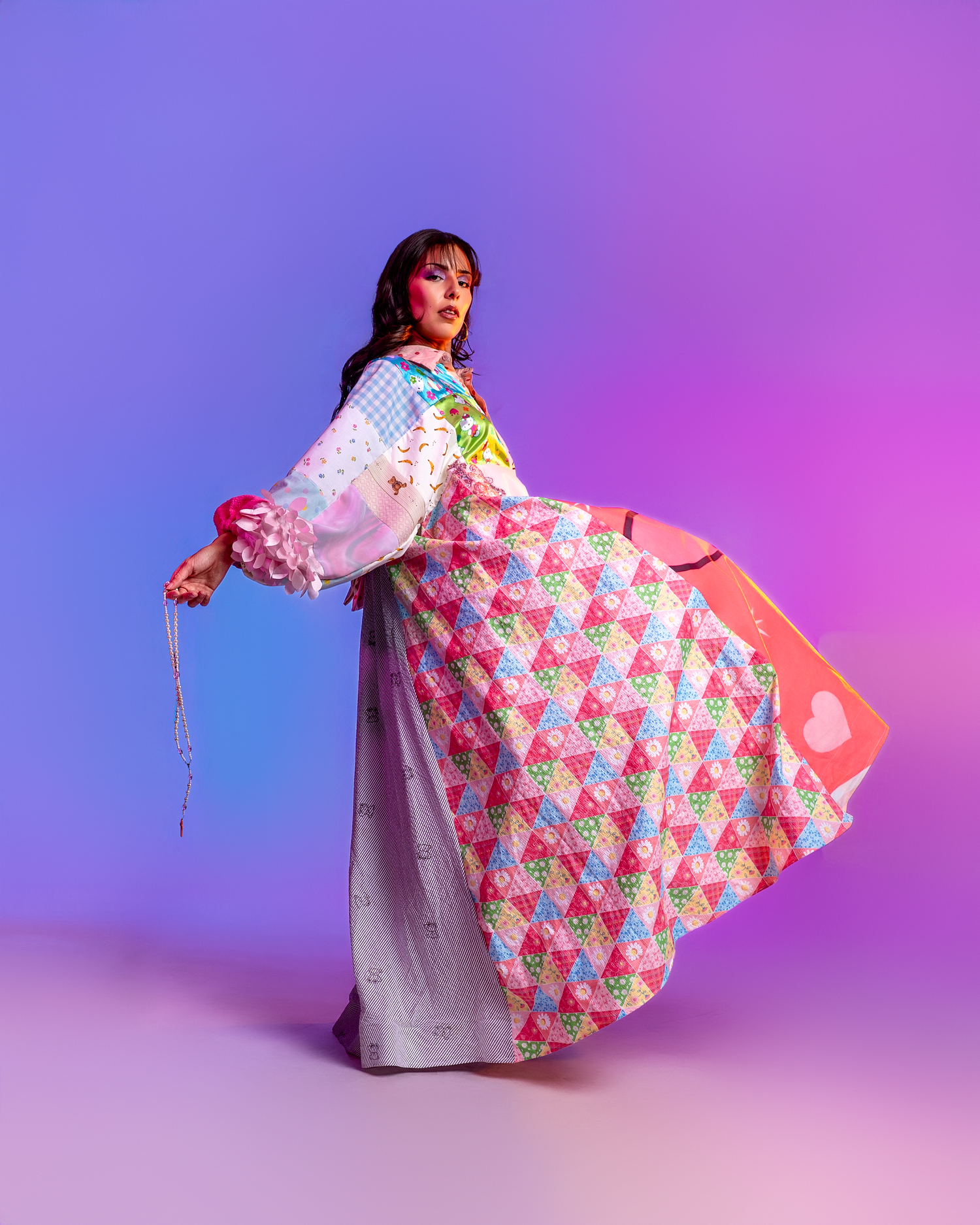 Floral print dress with flowing movement captured against purple studio background.