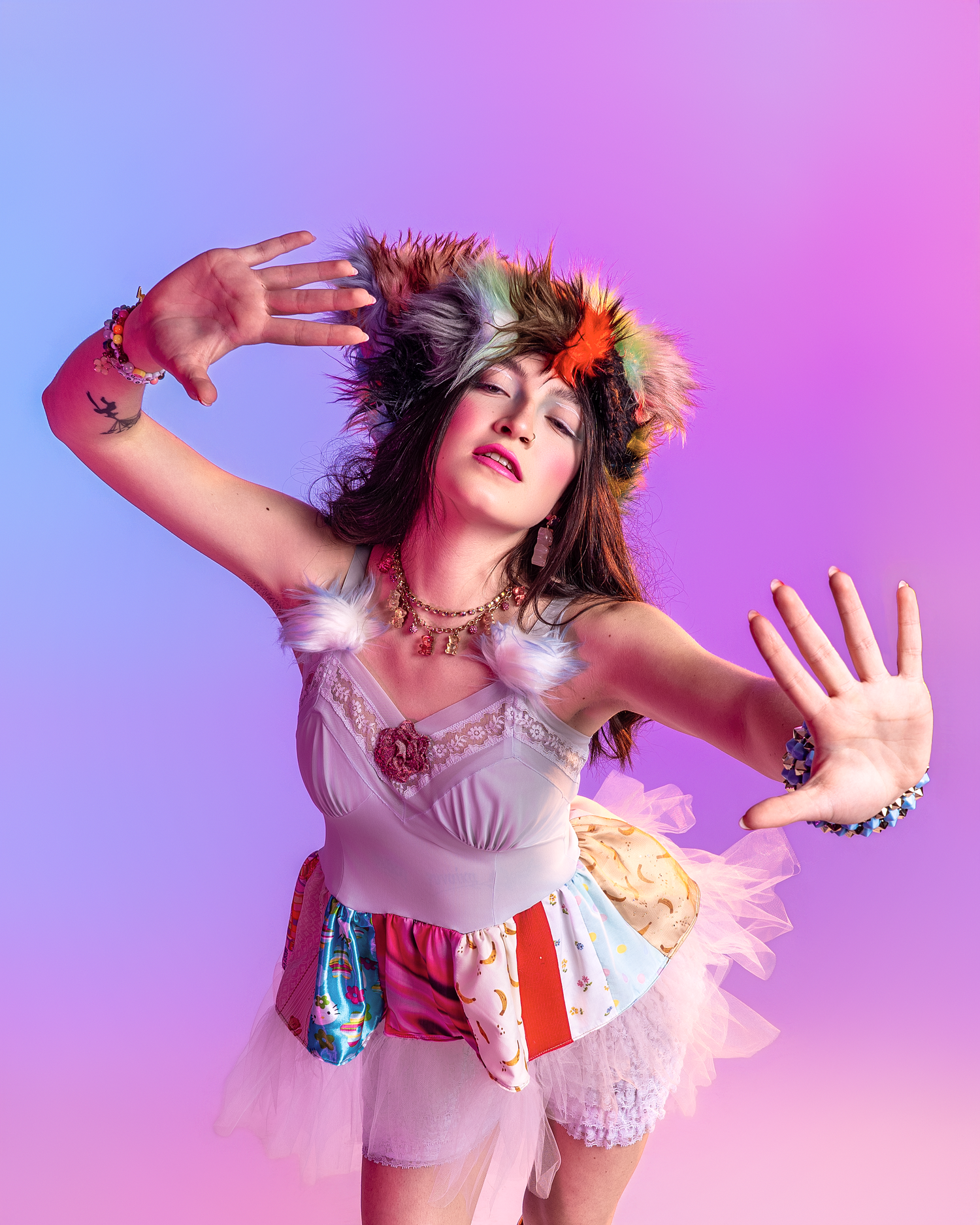 Dramatic dance-like pose in white ruffled outfit against purple studio lighting.