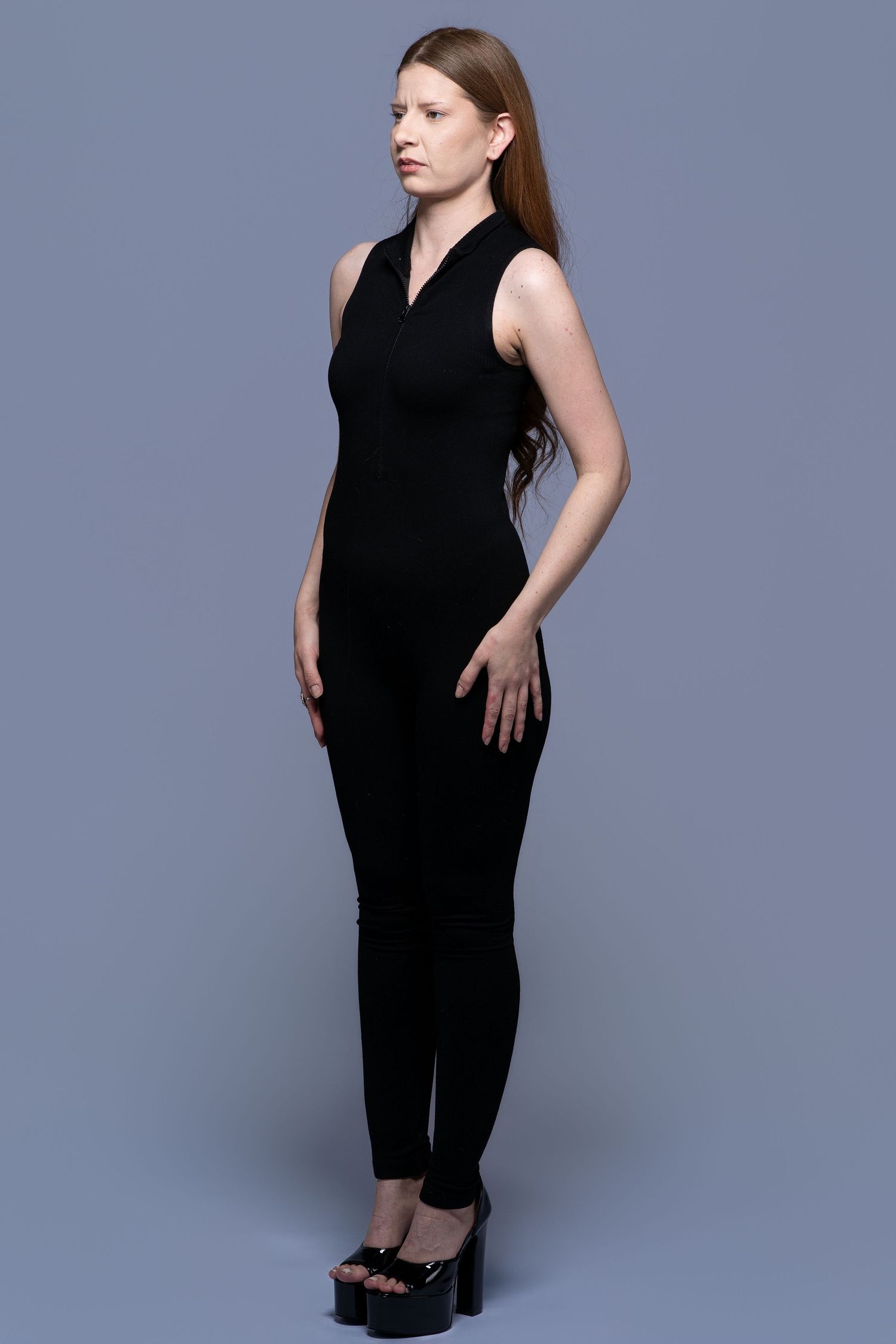 A figure in a sleek black jumpsuit poses confidently against a gray backdrop in four different angles.