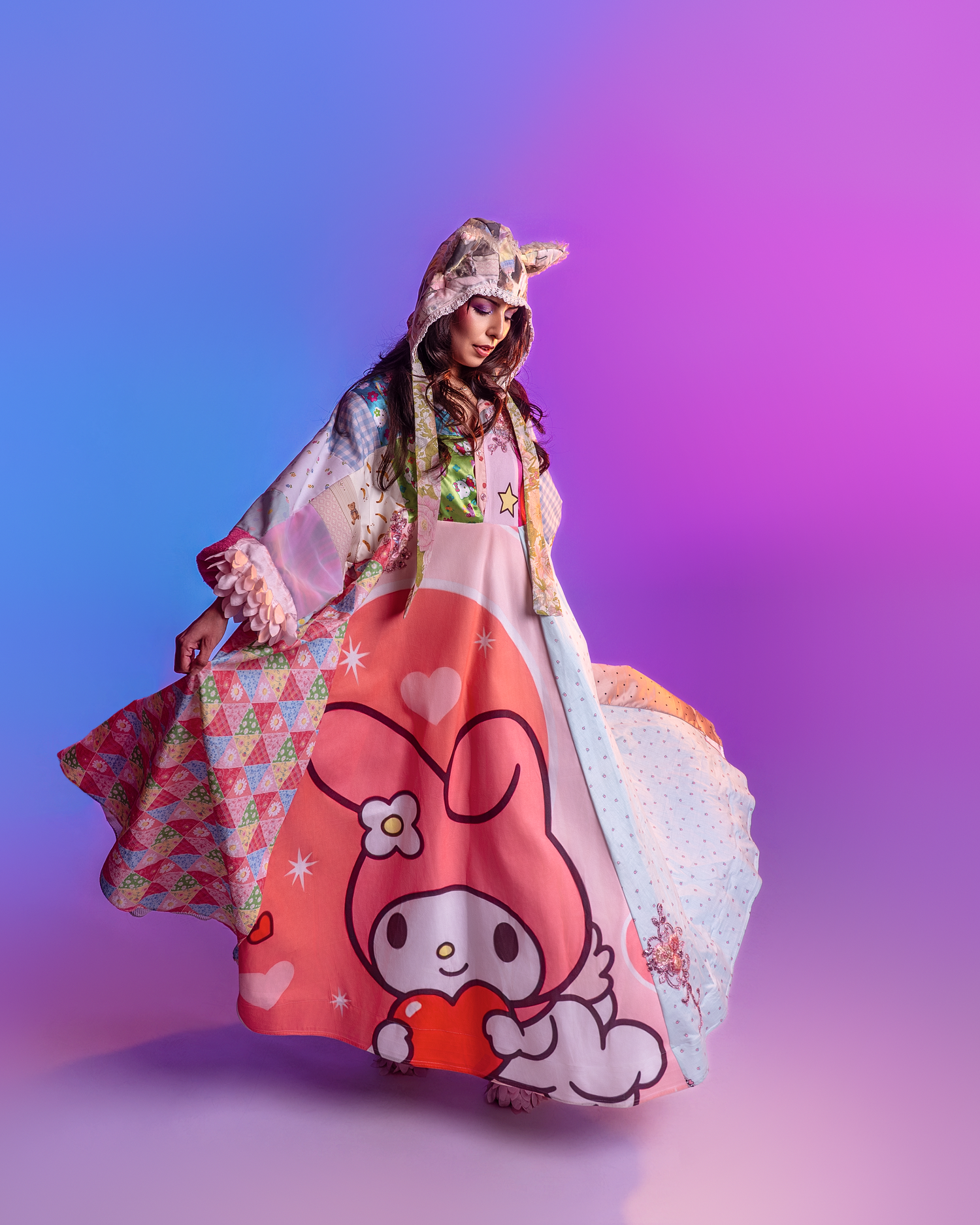 Flowing dress with cartoon character print photographed against purple-blue gradient background.