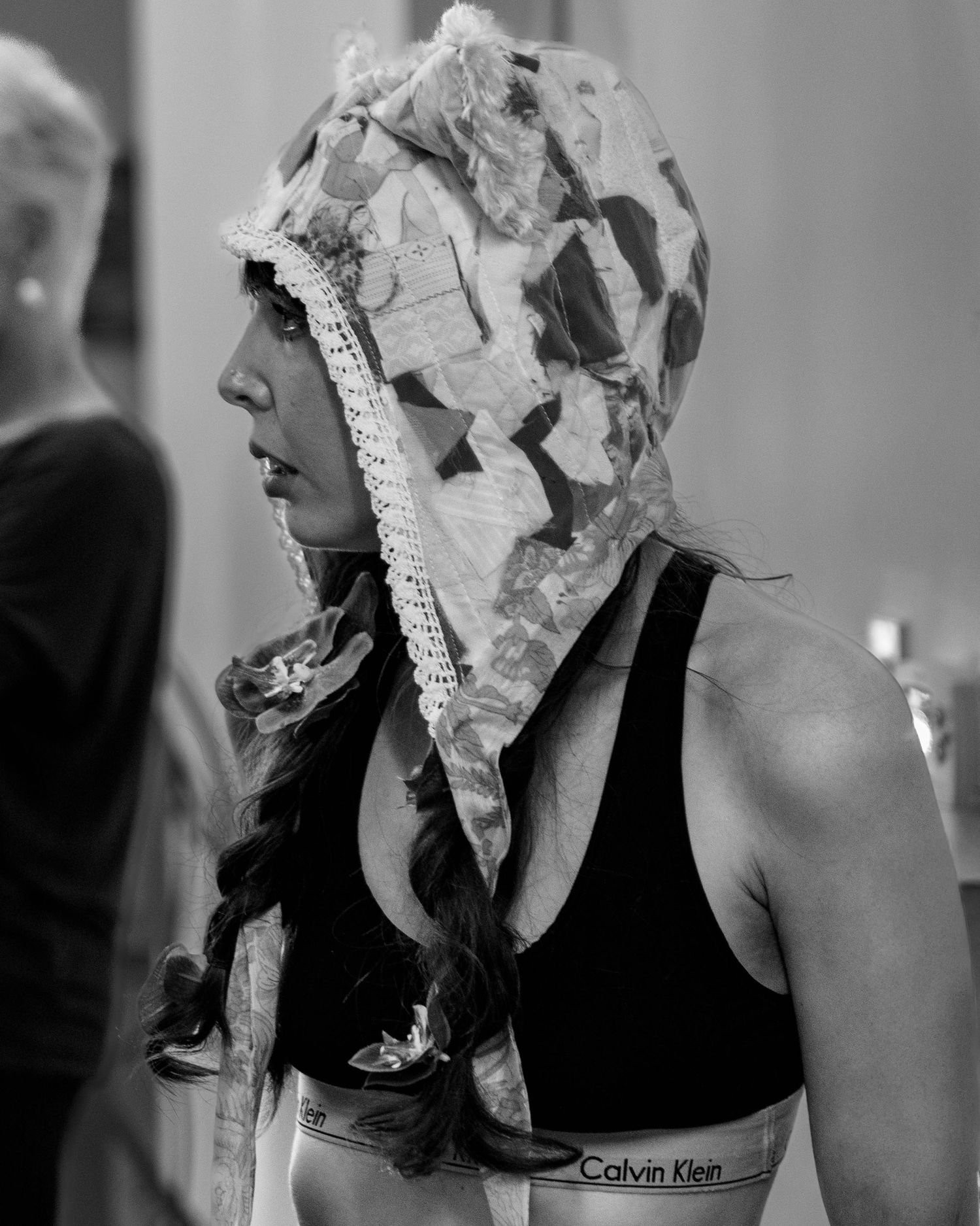 Black and white portrait with newspaper mask in artistic studio setting.
