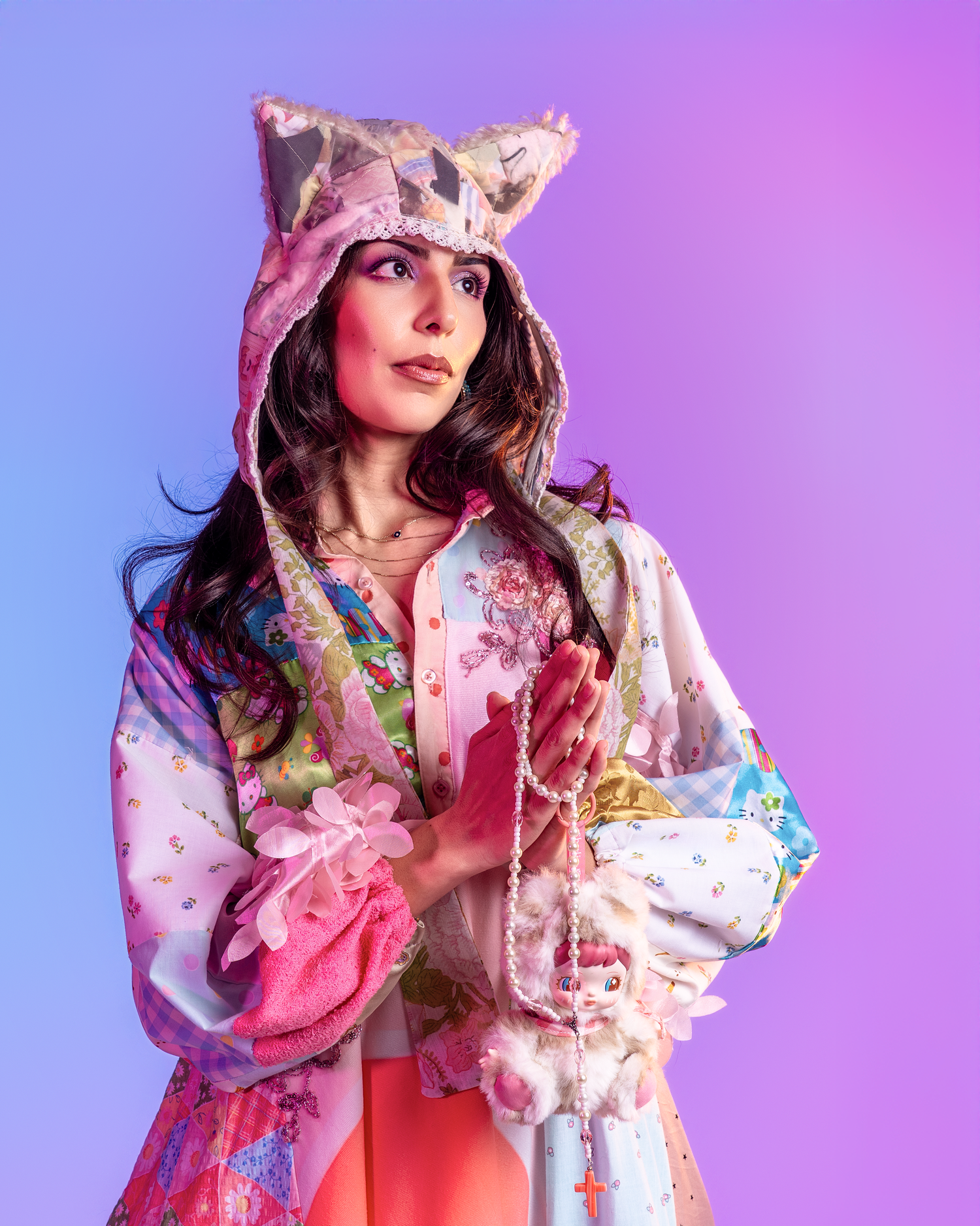 Whimsical fashion pose in a pink and white patterned dress with decorative accessories.
