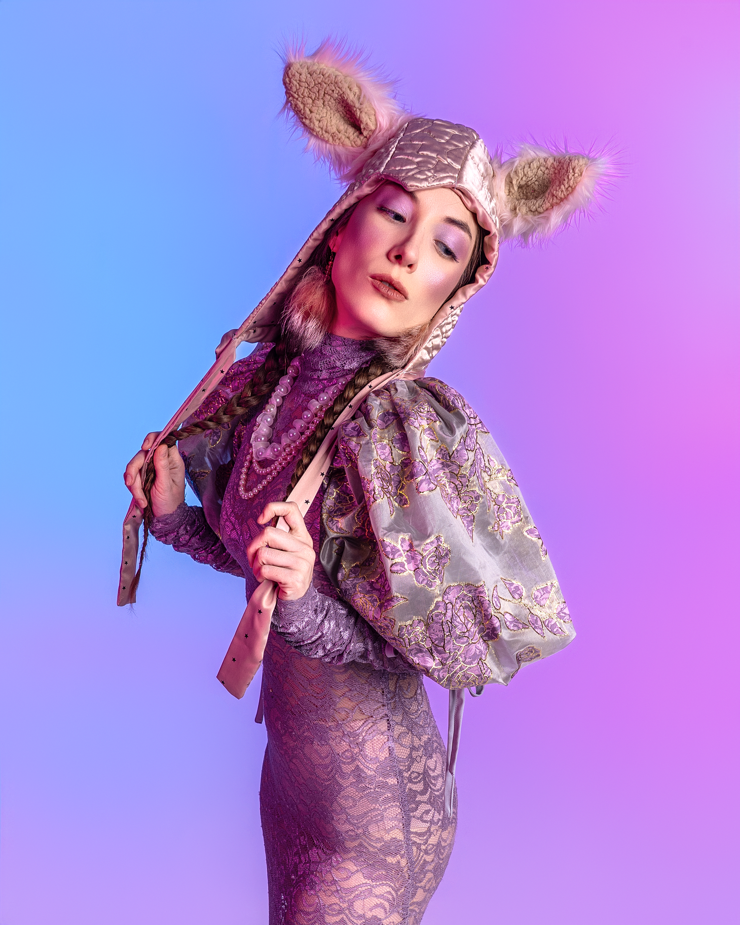 Elegant purple lace dress with furry accessories captured in dramatic studio lighting.