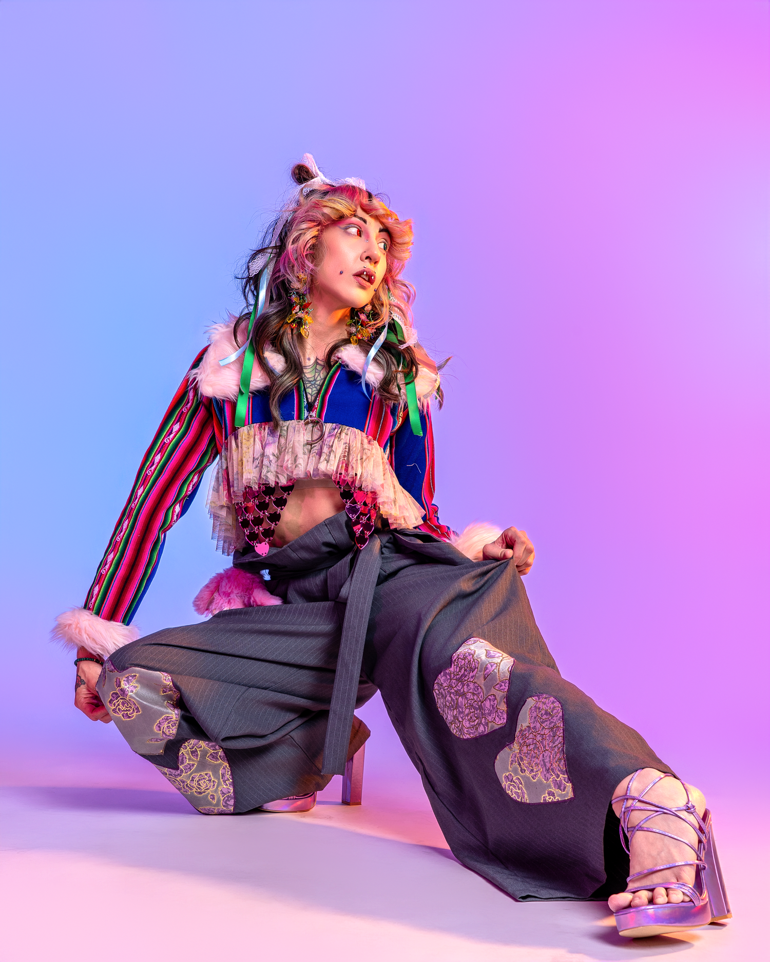 Energetic fashion pose featuring navy jumpsuit with glitter heart details on purple background.