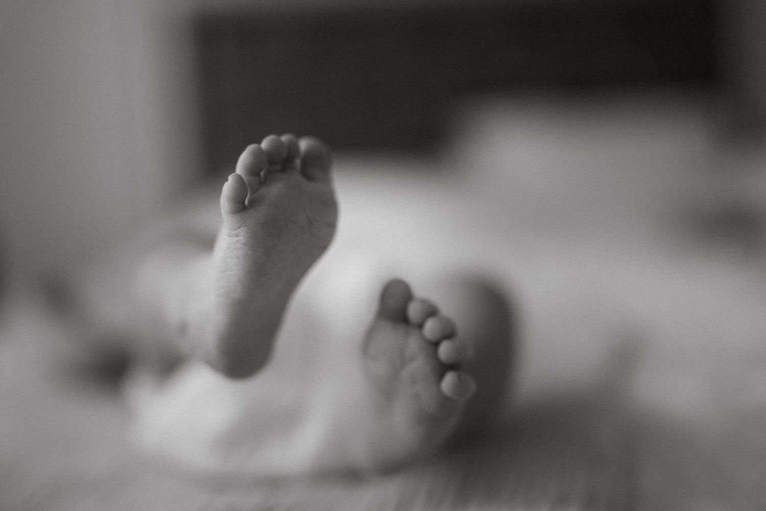 A series of black and white close-up photographs showing baby's feet in detail.